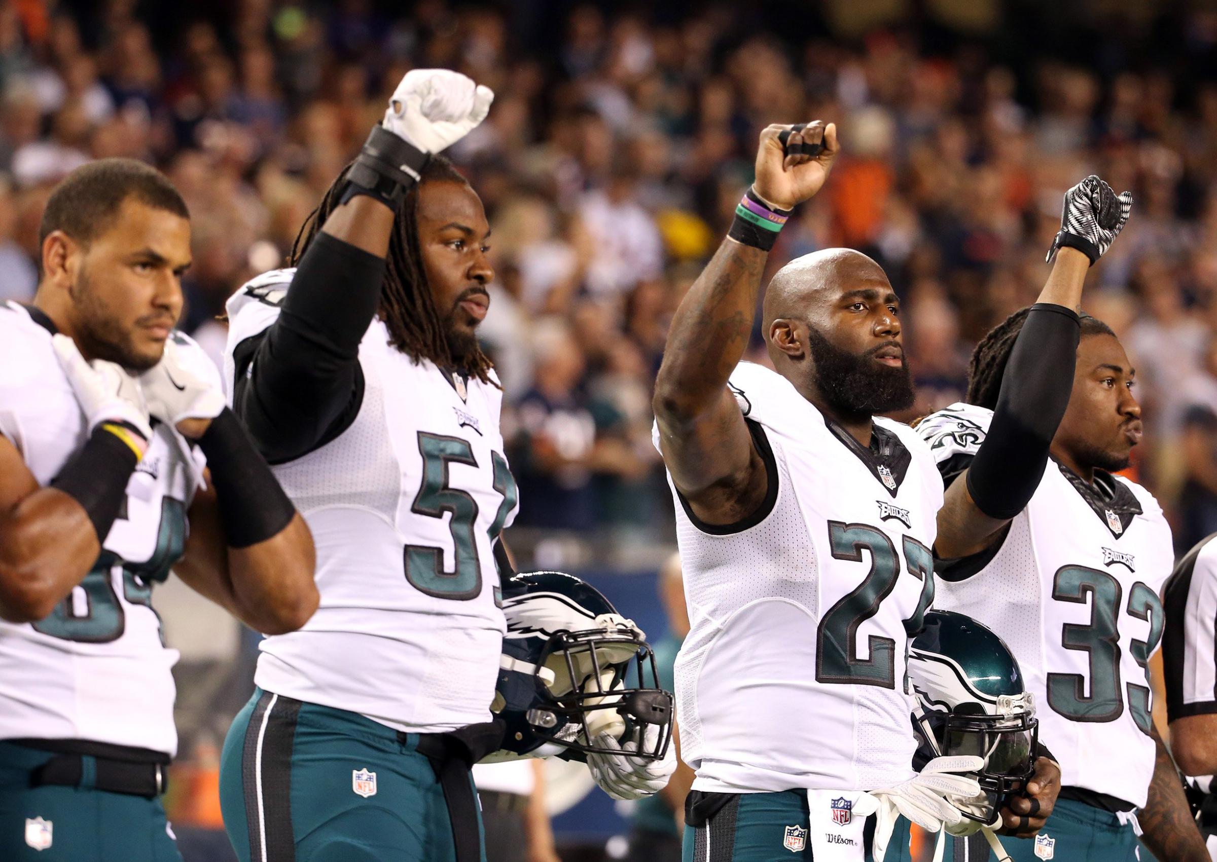 Philadelphia Eagles players Steven Means (51), Malcolm Jenkins (27) and Ron Brooks (33) raise their fists in the air during the national anthem for a game against the Chicago Bears at Soldier Field in Chicago on Sept. 19, 2016.