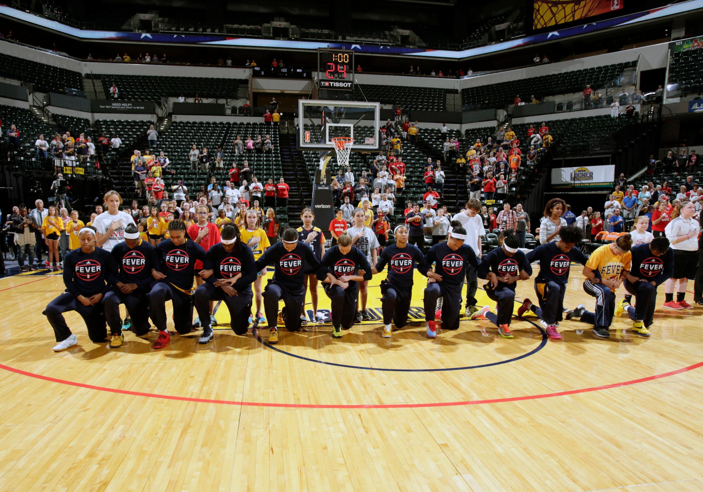 The Indiana Fever kneel during the National Anthem before the game against the Phoenix Mercury during Round One of the 2016 WNBA Playoffs at Bankers Life Fieldhouse in Indianapolis, Indiana, on Sept. 21, 2016.