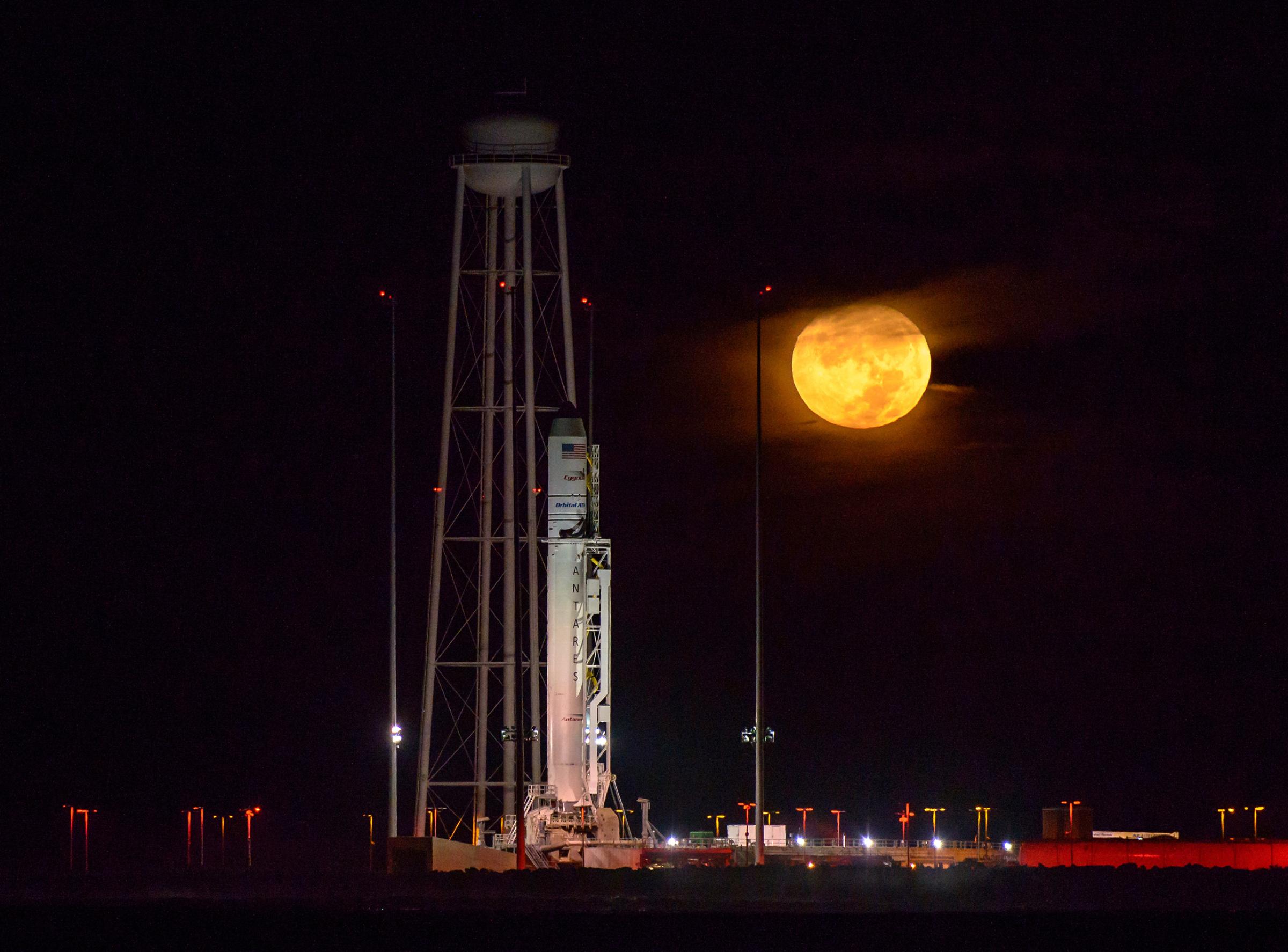 The Orbital ATK Antares rocket, with the Cygnus spacecraft onboard, is seen on launch Pad-0A as the moon sets, predawn, on Oct. 15, 2016 at NASA's Wallops Flight Facility in Virginia.