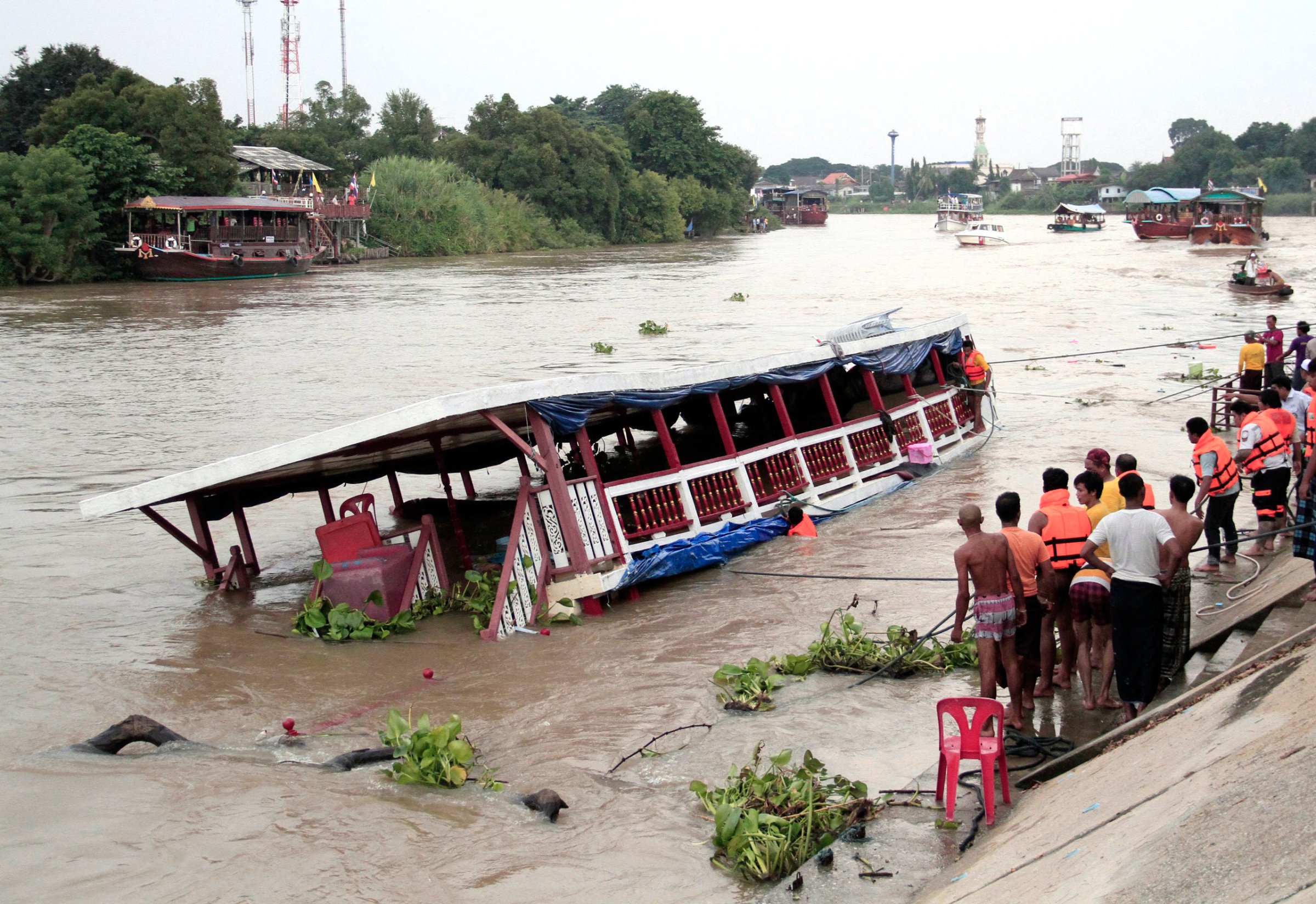 Thai rescue teams search for victims after a boat capsized at Chao Phraya River in Ayuthaya Province, Thailand, Sunday, Sept. 18, 2016. Thai news reports say at least 13 people were killed when a double-decker passenger boat carrying more than 100 people capsized in the Chao Phraya River north of Bangkok. Some people were still missing after the accident, which occurred when the boat was involved in a collision Sunday afternoon, but it was not immediately clear how many. (Dailynews via AP)