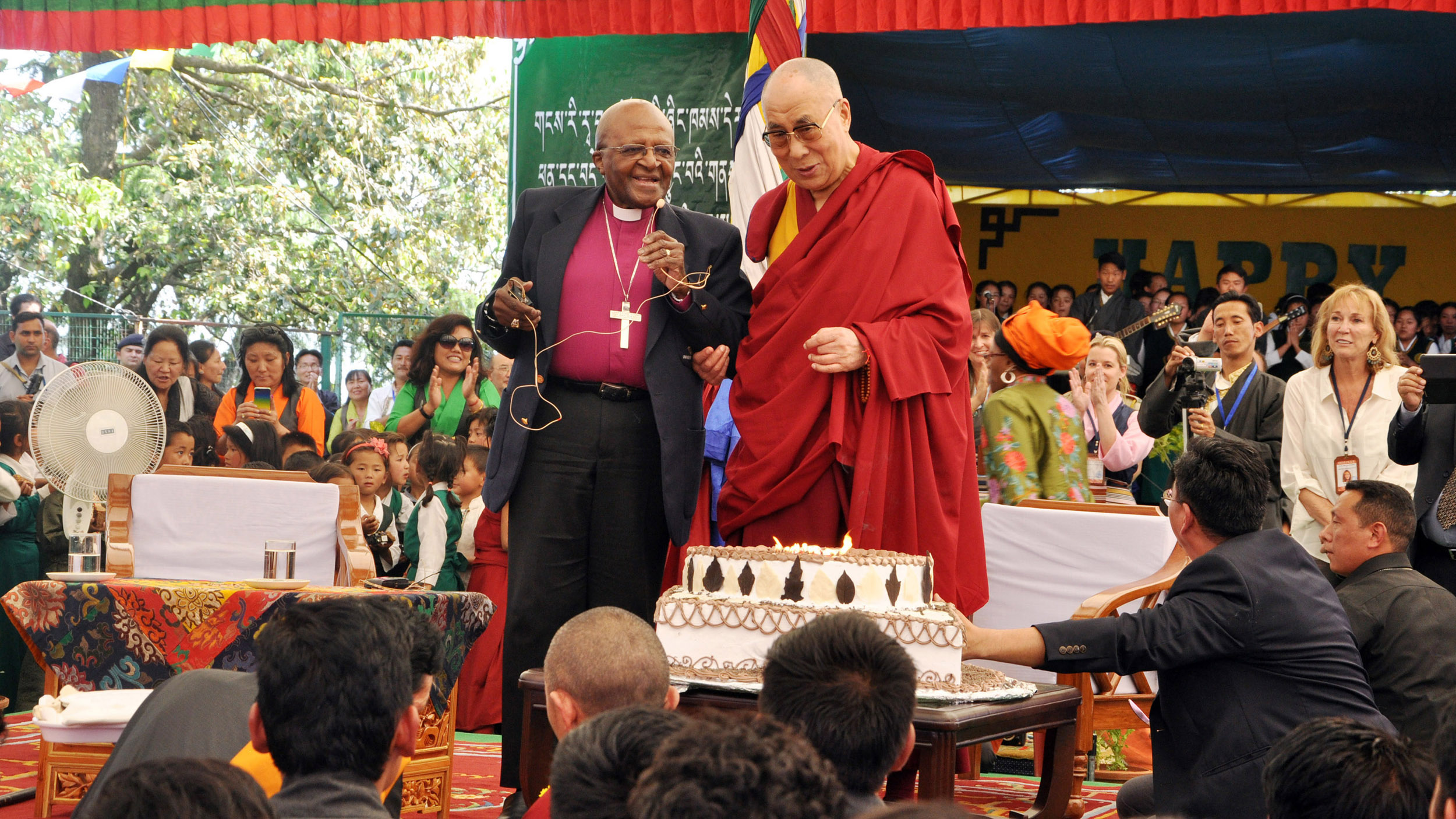 Spiritual leader Dalai Lama to blow out candles on his birthday cake as retired Archbishop Desmond Tutu looks on at the Tibetan Childrens Village School in Dharmsala, India, on April 23, 2015.