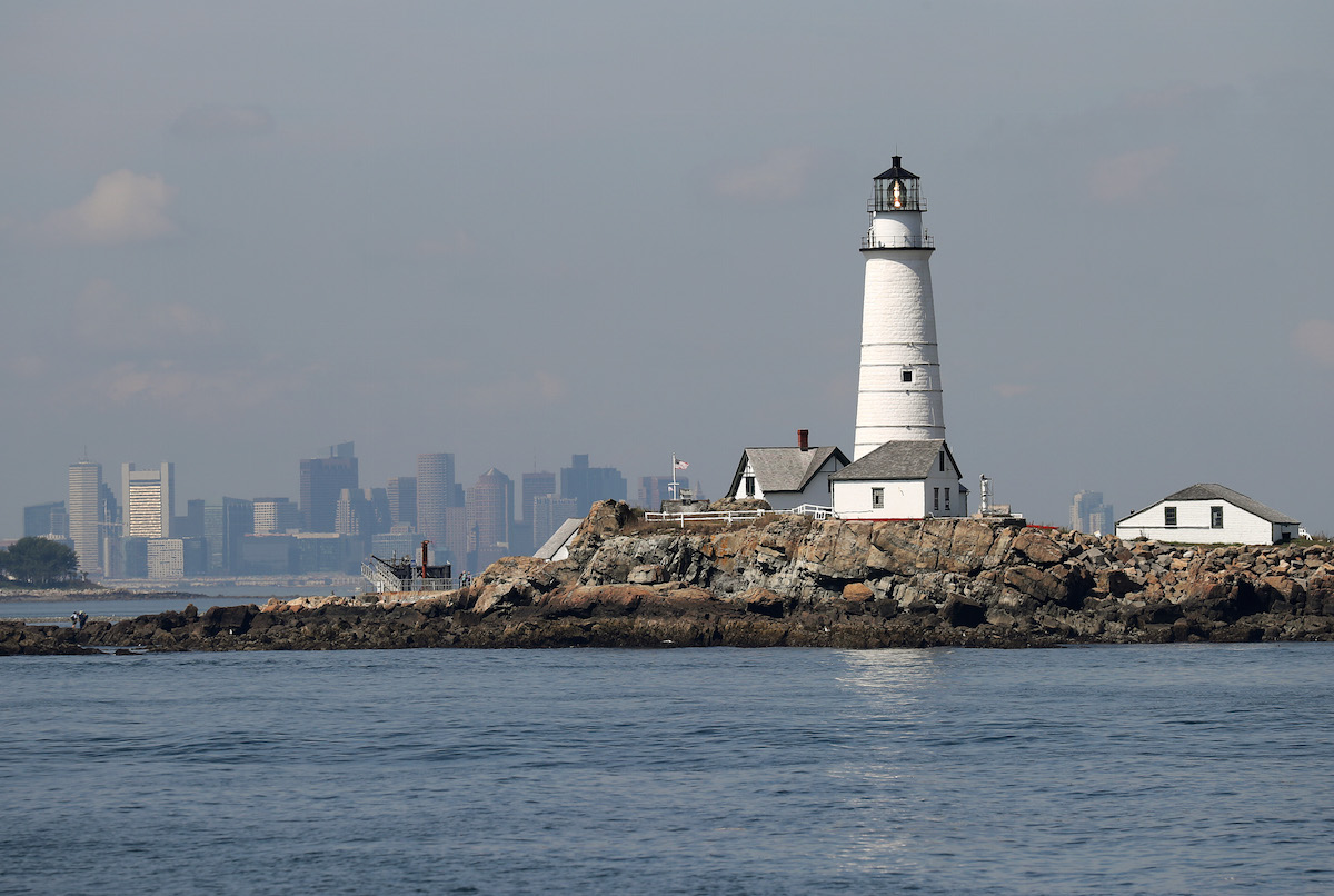 A view from the water against a backdrop of the city's skyline of Boston Light, the country's first lighthouse, located on Little Brewster Island in the Boston Harbor Islands National Recreation Area, Sept. 9, 2016. (Boston Globe / Getty Images)
