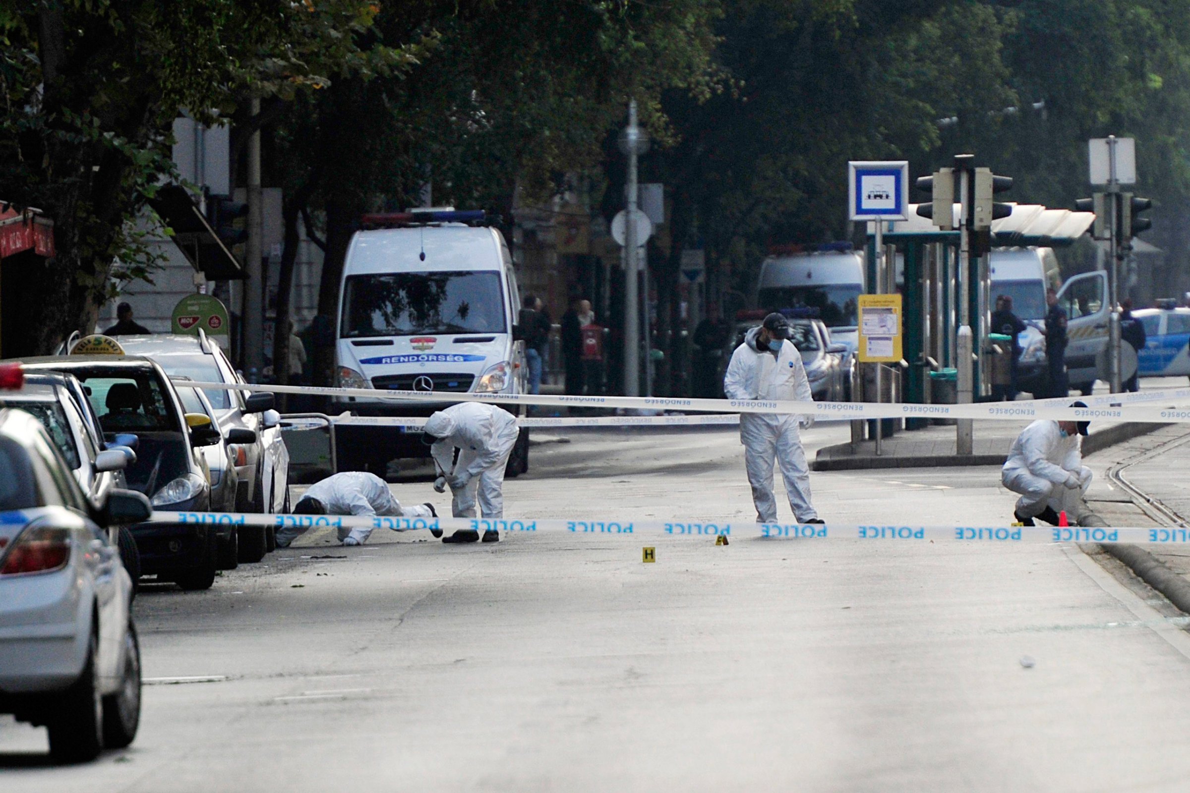 Police forensic experts examine the scene in central Budapest, Hungary, Sunday, Sept. 25, 2016, after an explosion of yet unknown origin occured in a shop late Saturday night. According to an expert apparently a home made bomb went off in front of the shop. The explosion injured two patrolling policemen. (Peter Lakatos/MTI via AP)