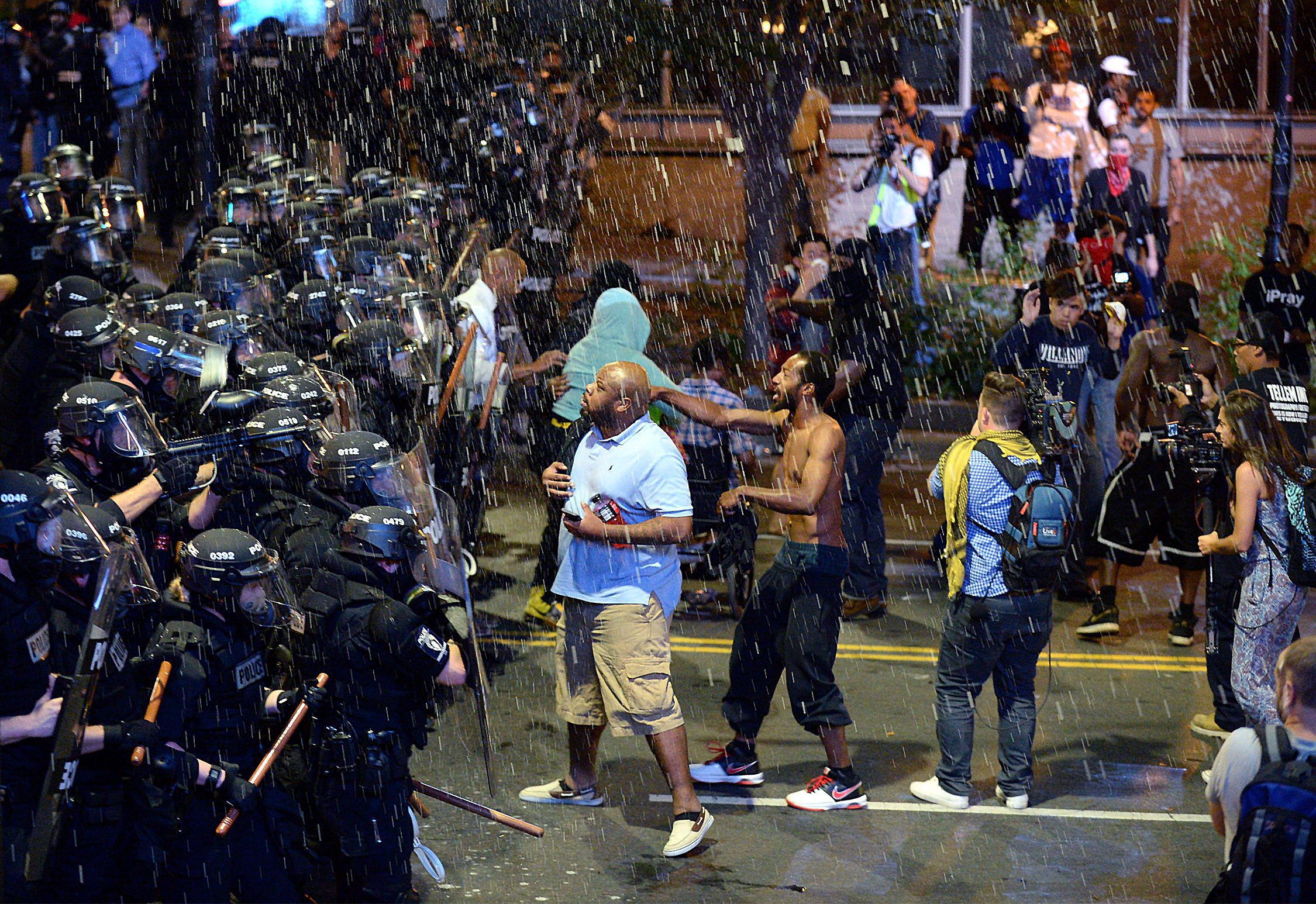 Debris falls upon police officers and protesters as officers began to push protesters from the intersection in Charlotte, N.C. on Sept. 21, 2016.