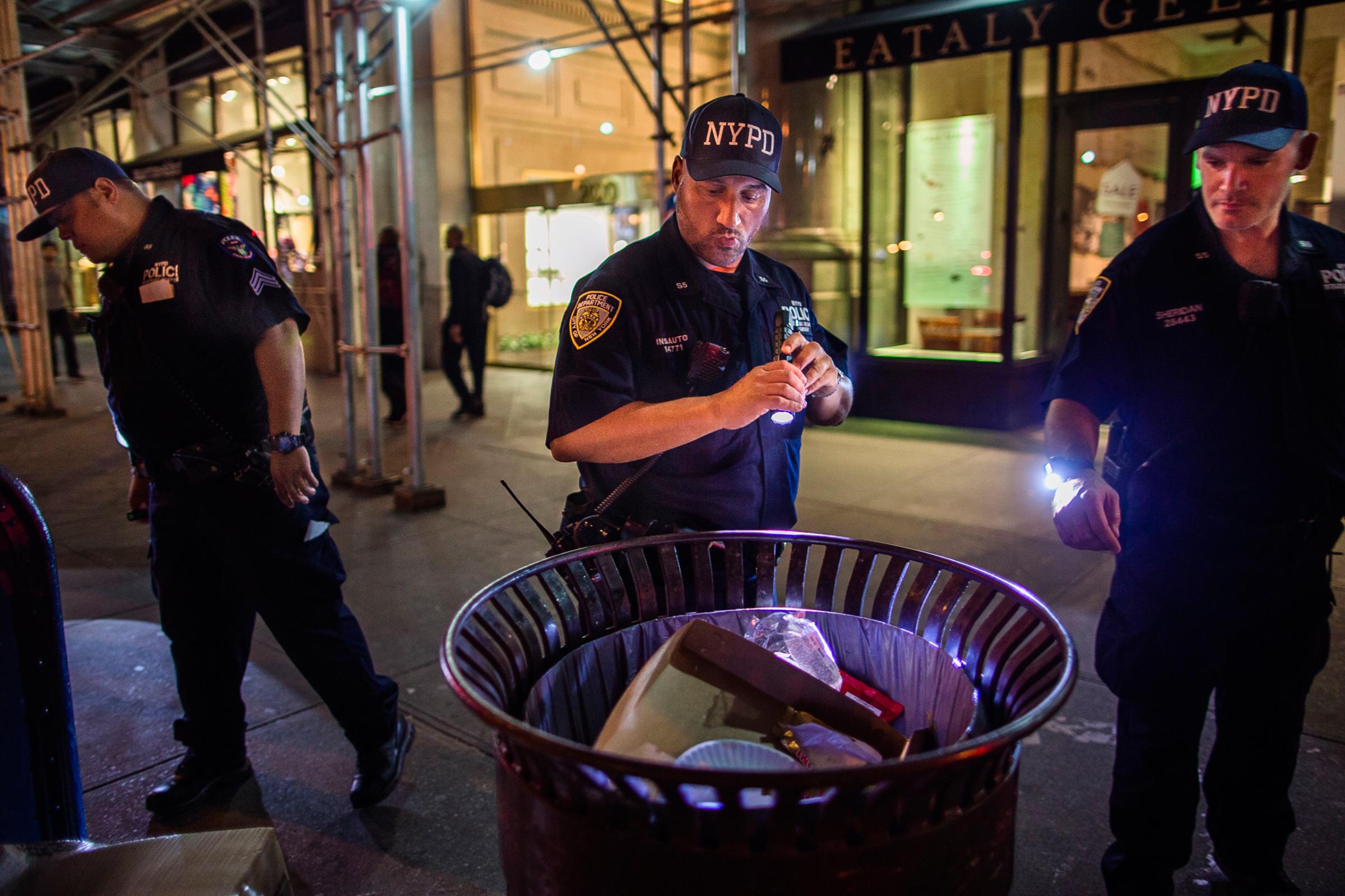Police officers look for suspicious packages along Fifth Avenue near the scene of an explosion on West 23rd Street and 6th Avenue in Manhattan's Chelsea neighborhood, in New York, early Sunday, Sept. 18, 2016. An explosion rocked the block of West 23rd Street between Sixth and Seventh Avenues at 8:30 p.m. Saturday. Officials said more than two dozen people were injured. Most of the injuries were minor. (AP Photo/Andres Kudacki)