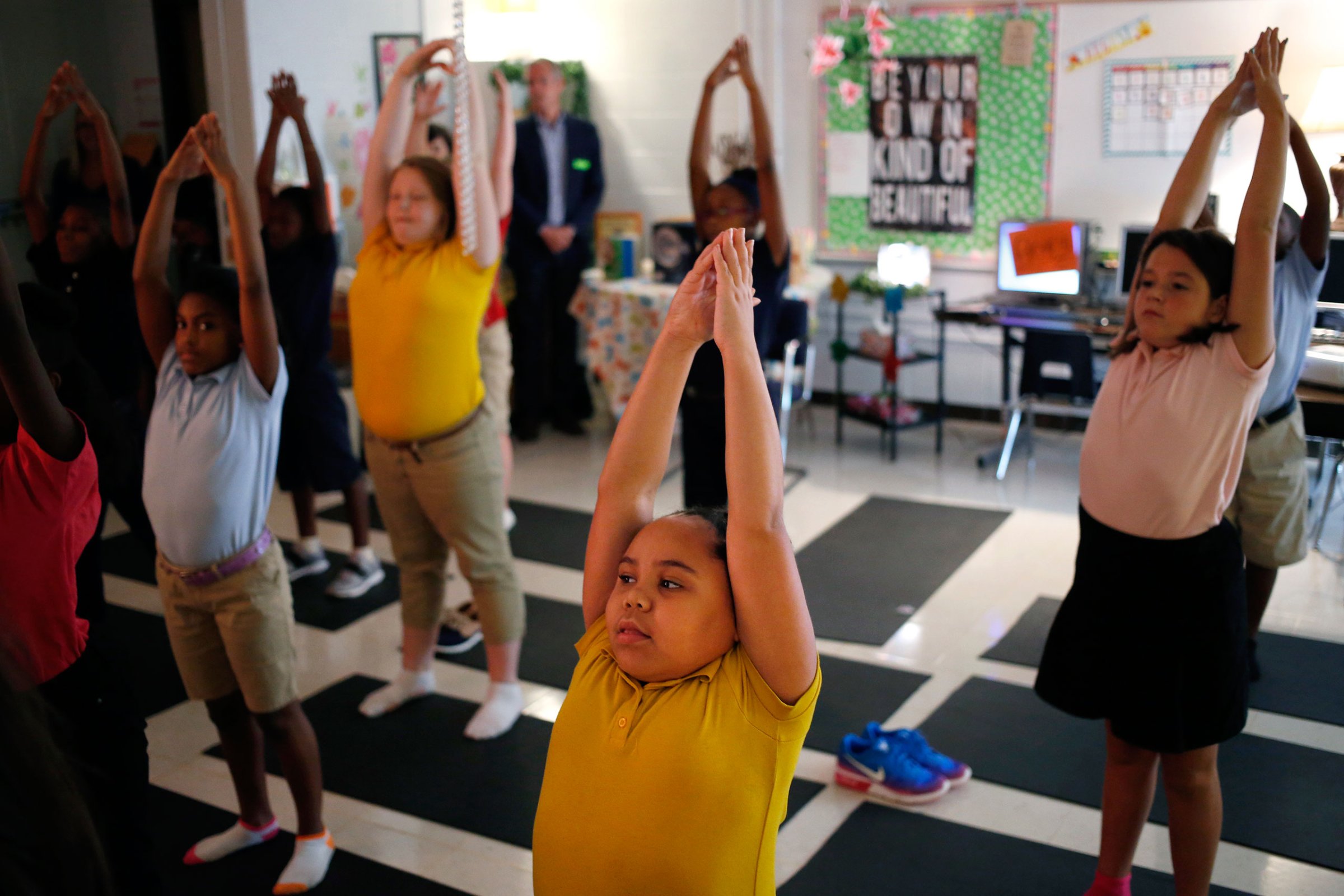 Fifth-graders flow through yoga-inspired poses in a mindfulness class at a public school in Louisville, Ky.