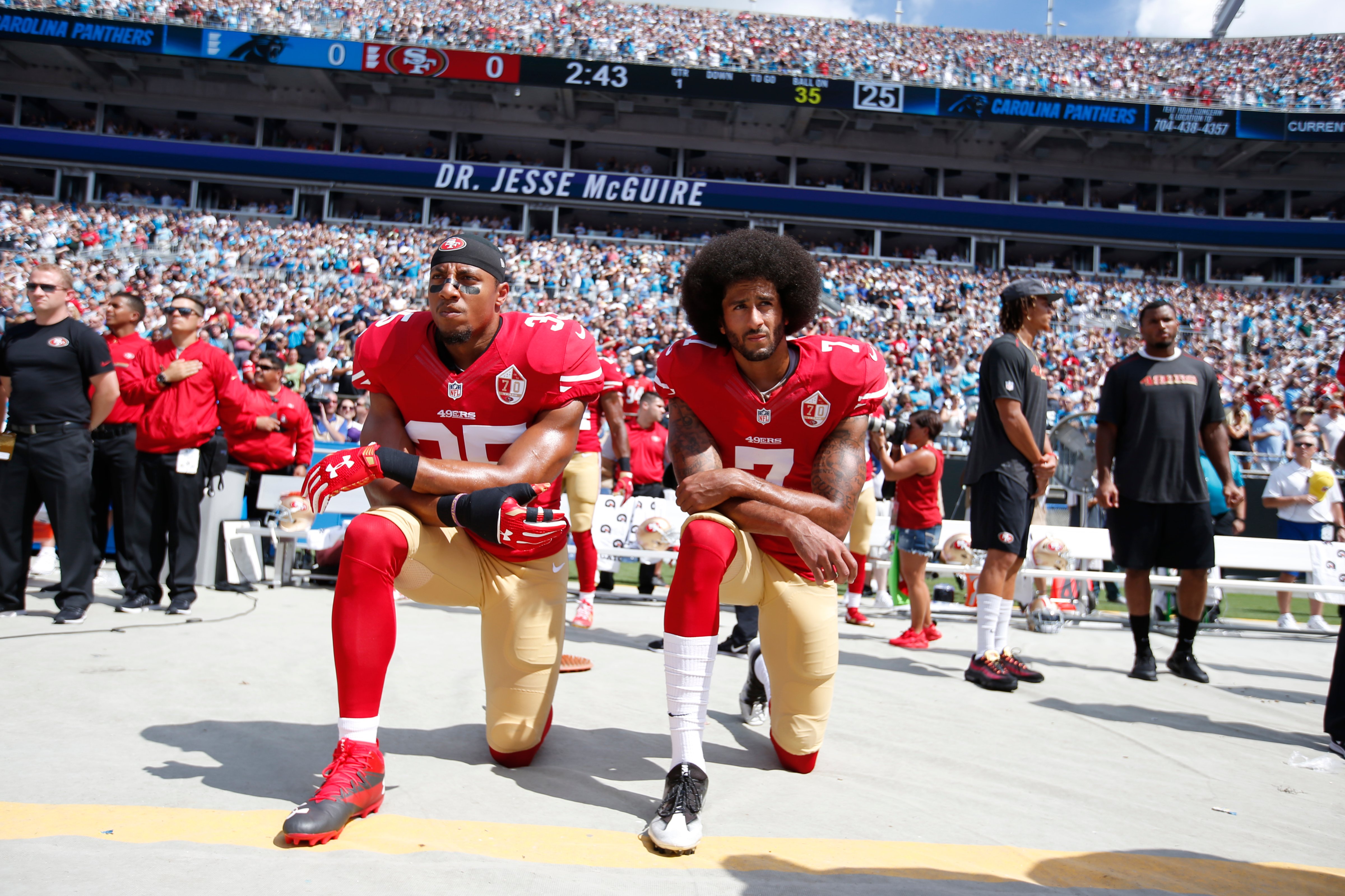 Eric Reid #35 and Colin Kaepernick #7 of the San Francisco 49ers kneel on the sideline, during the anthem, prior to the game against the Carolina Panthers at Bank of America Stadium in Charlotte, N.C., on Sept. 18, 2016. (Michael Zagaris—Getty Images)
