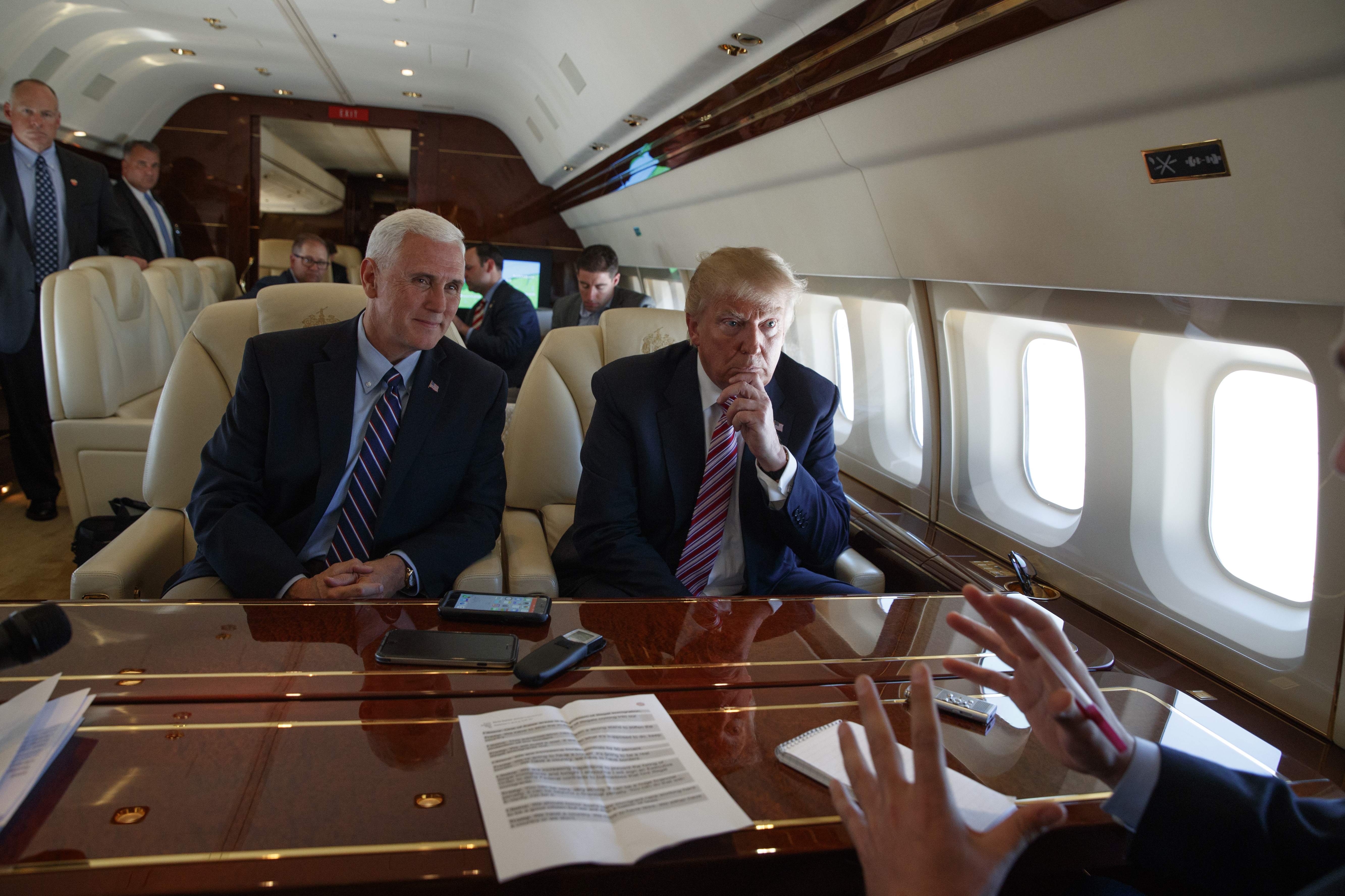 Republican presidential candidate Donald Trump talks with press,  Sept. 5, 2016, aboard his campaign plane while flying over Ohio, as Vice presidential candidate Gov. Mike Pence, R-Ind., left, looks on.