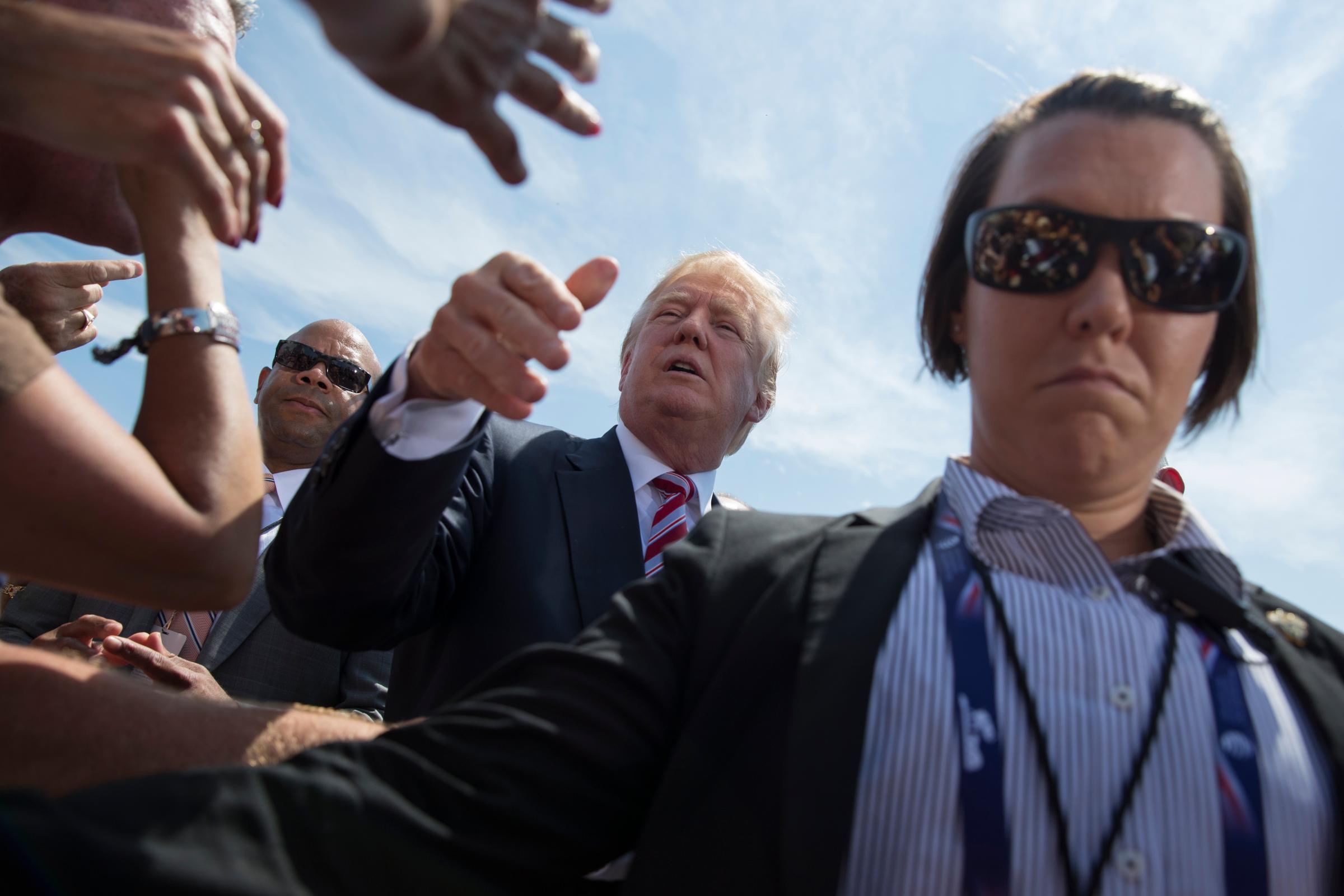 Republican presidential candidate Donald Trump shakes hands with supporters after landing at a site of the Republican National Convention, July 20, 2016, in Cleveland.