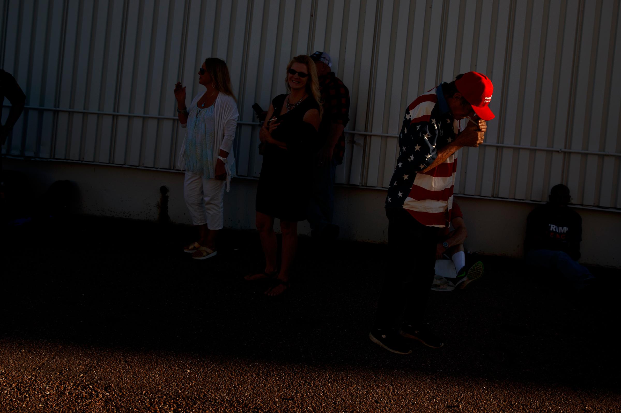 Robert Einspahr, of Denver, lights a cigarette as he waits for the arrival Republican presidential candidate Donald Trump to a campaign rally, Sept. 17, 2016, in Colorado Springs, Colo.
