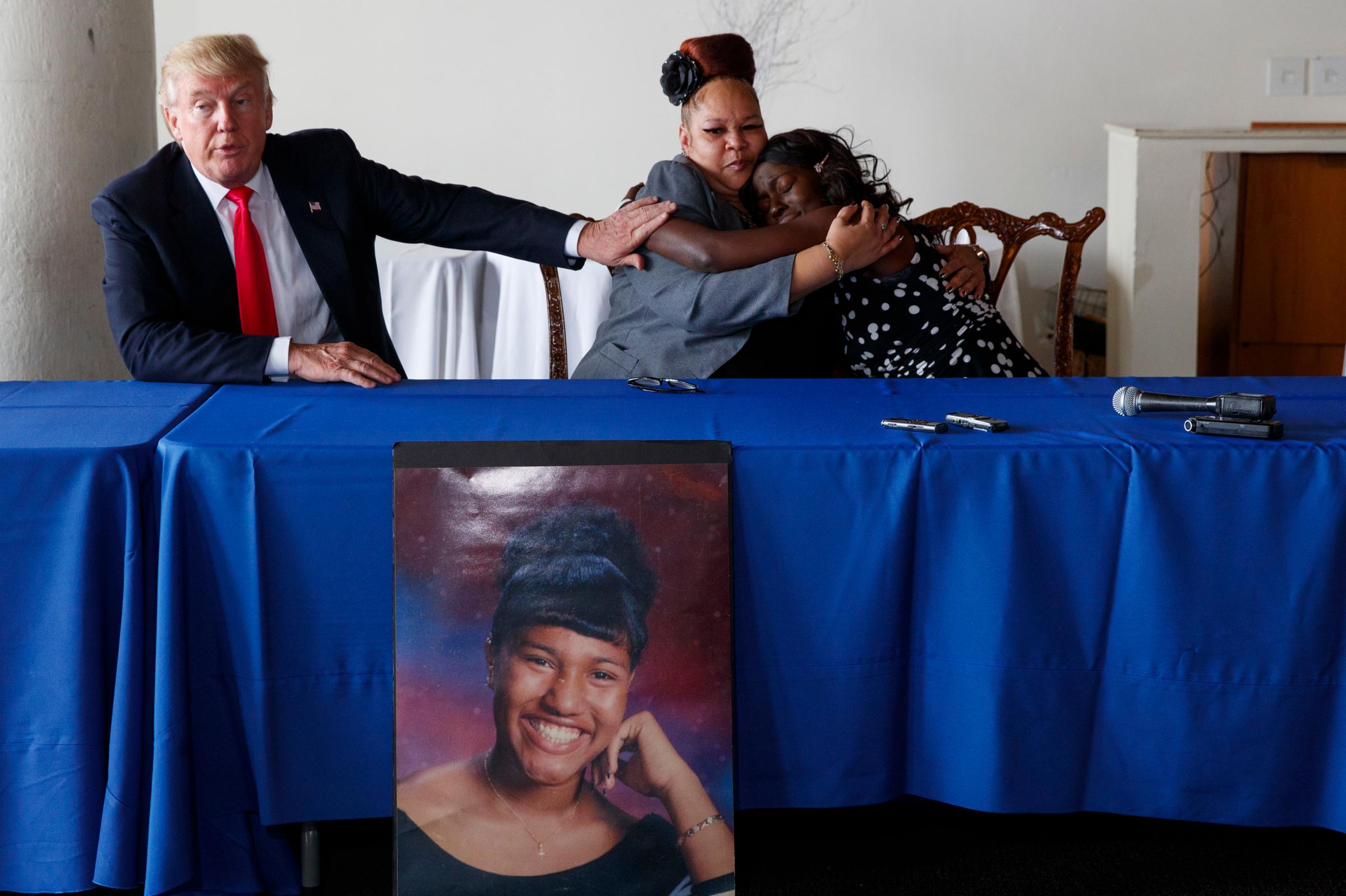 Republican presidential candidate Donald Trump comforts Shalga Hightower, center, as she hugs family spokesman Charmil Davis, Sept. 2, 2016, in Philadelphia. Hightower's daughter, Iofemi Hightower, was murdered in a 2007 attack at a Newark schoolyard.