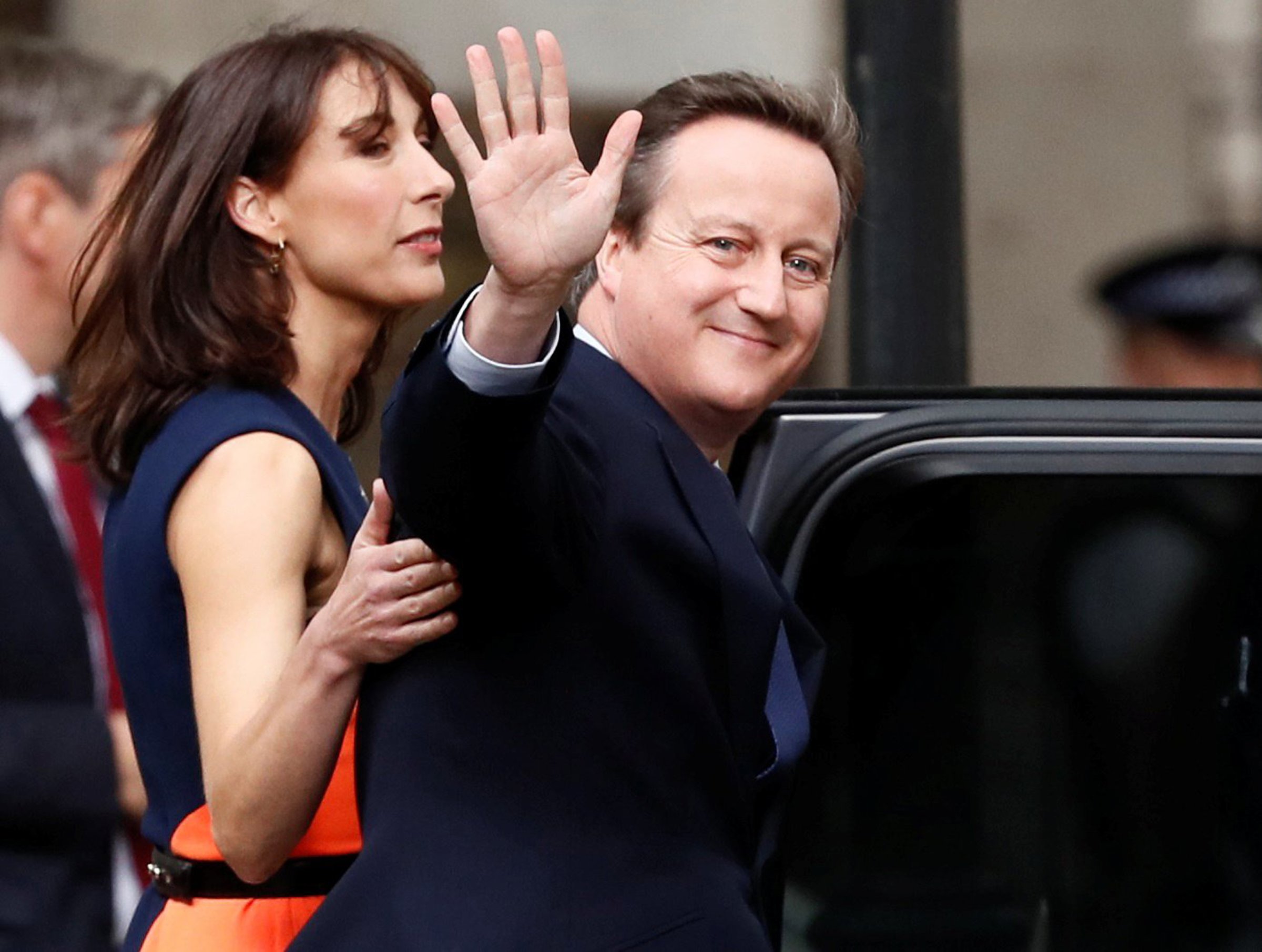 Britain's outgoing Prime Minister, David Cameron with his wife Samantha, waves in front of number 10 Downing Street, on his last day in office as Prime Minister, in central London, on July 13, 2016.