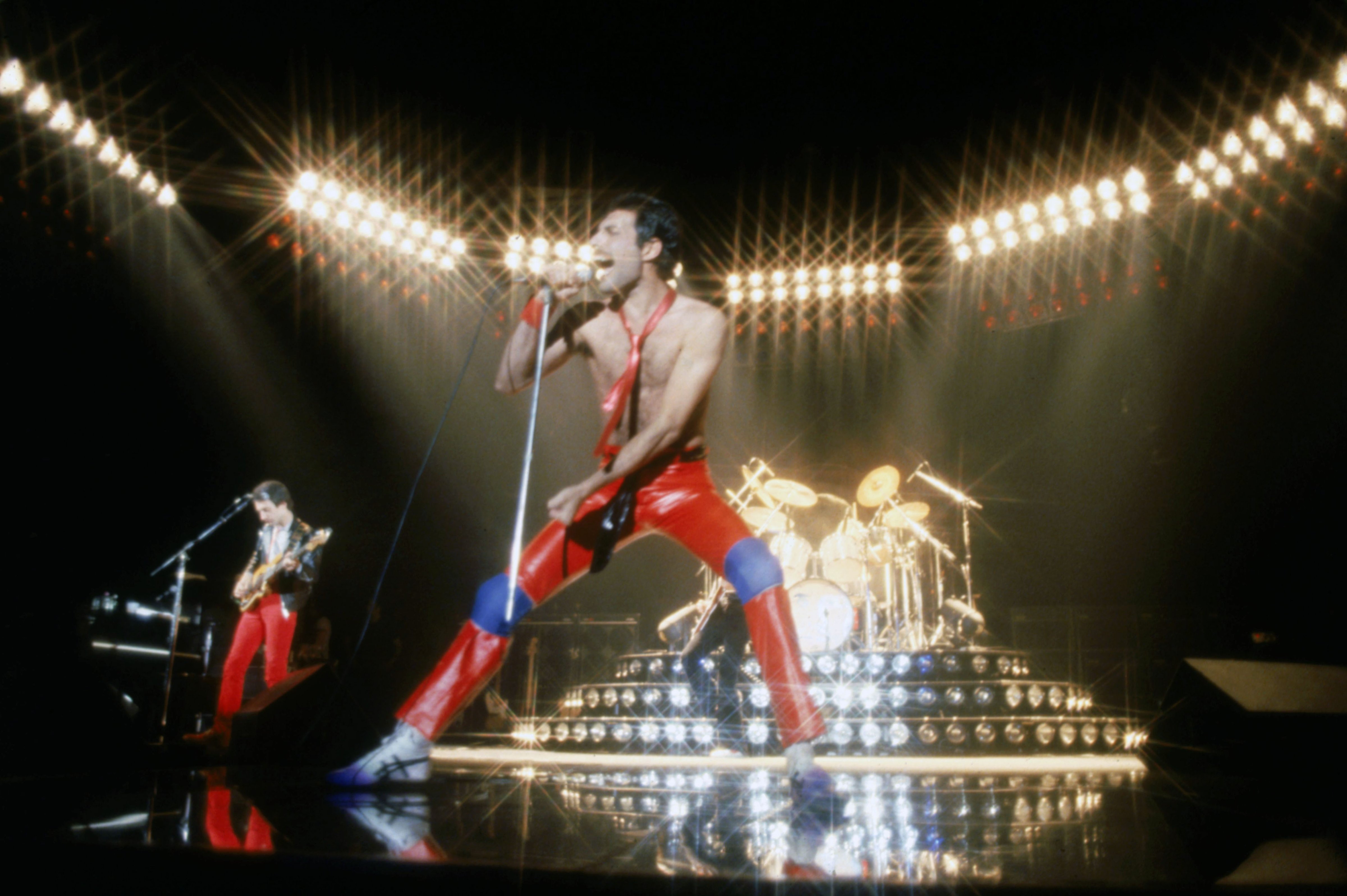 Musician John Deacon and Freddie Mercury  (C)(1946 - 1991) of British rock band Queen in concert, 1980.