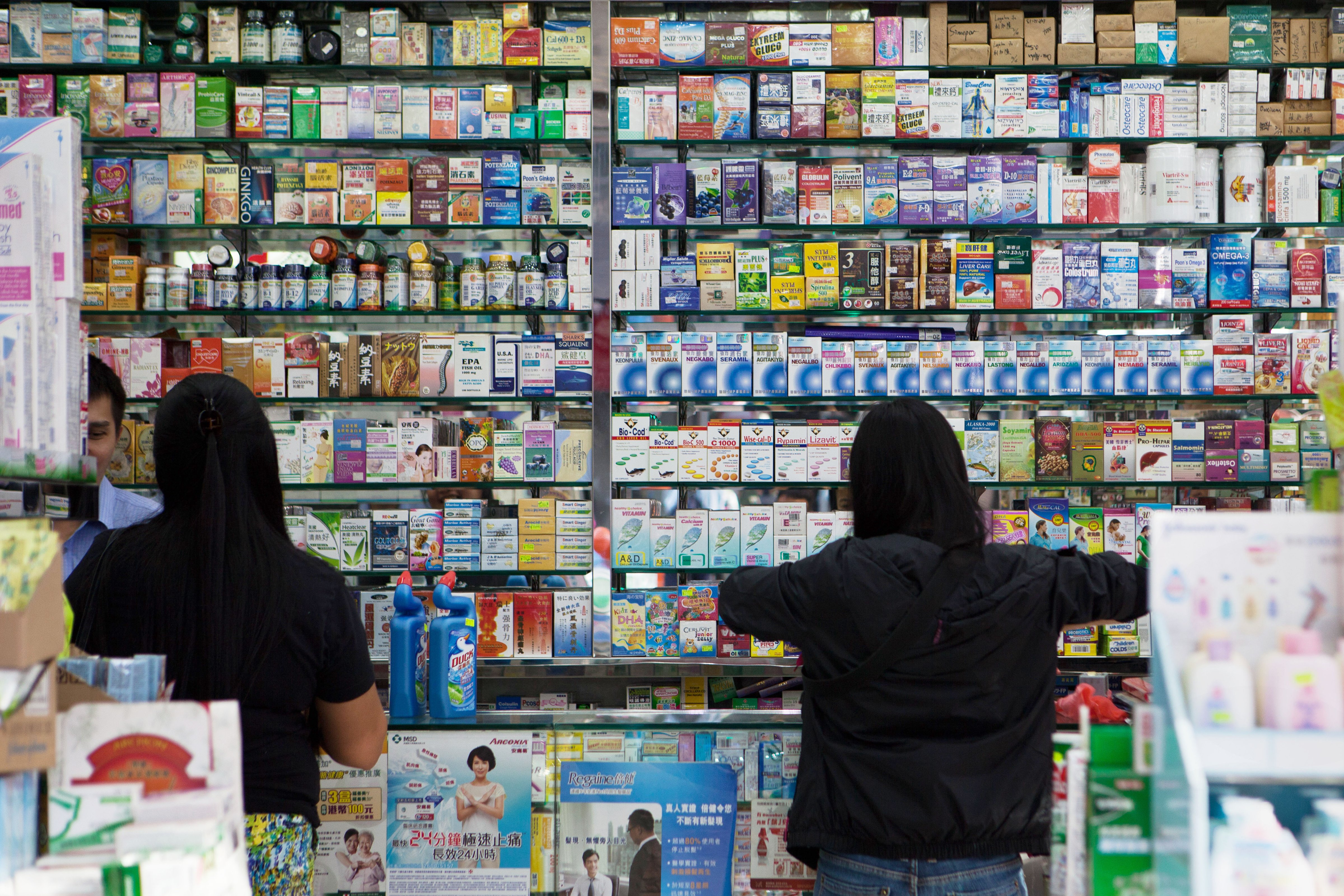 This picture taken on Nov. 18, 2013, shows customers buying goods in an independent pharmacy in Hong Kong. Safety fears over medication in mainland China are driving a risky illegal trade in cancer drugs in Hong Kong, experts say (AFP/Getty Images)