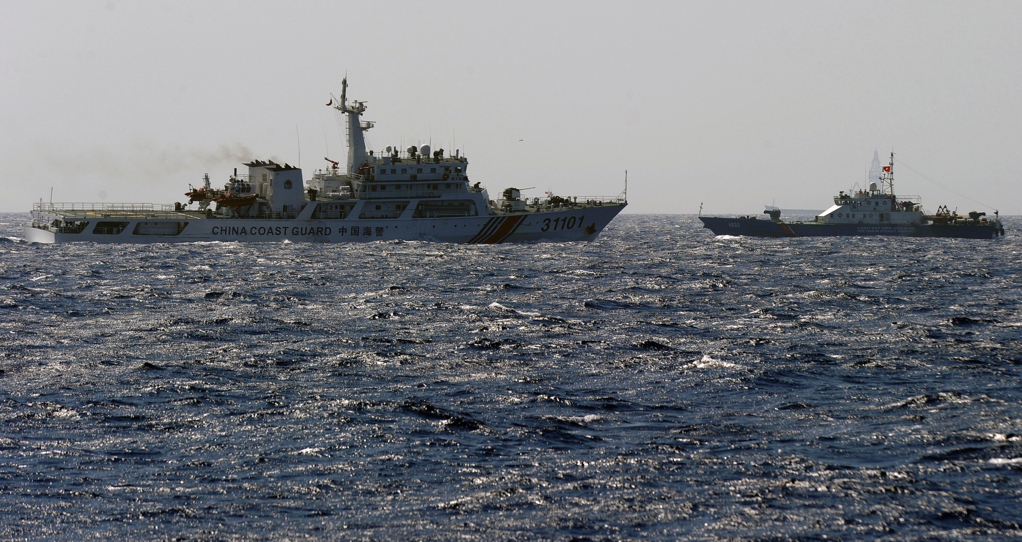 This picture taken on May 14, 2014 shows a China Coast Guard ship (L) chasing a Vietnam Coast Guard vessel near the site of a Chinese drilling oil rig in disputed waters in the South China Sea. (Hoang Dinh Nam—AFP/Getty Images)