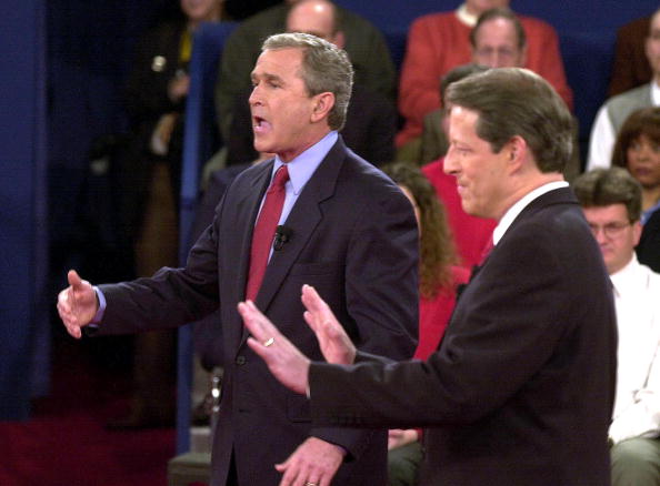 Republican presidential nominee George W. Bush (L) answers a question as Democratic presidential nominee Al Gore gestures during their town hall style debate with at Washington University in St. Louis, MO, 17 October, 2000.