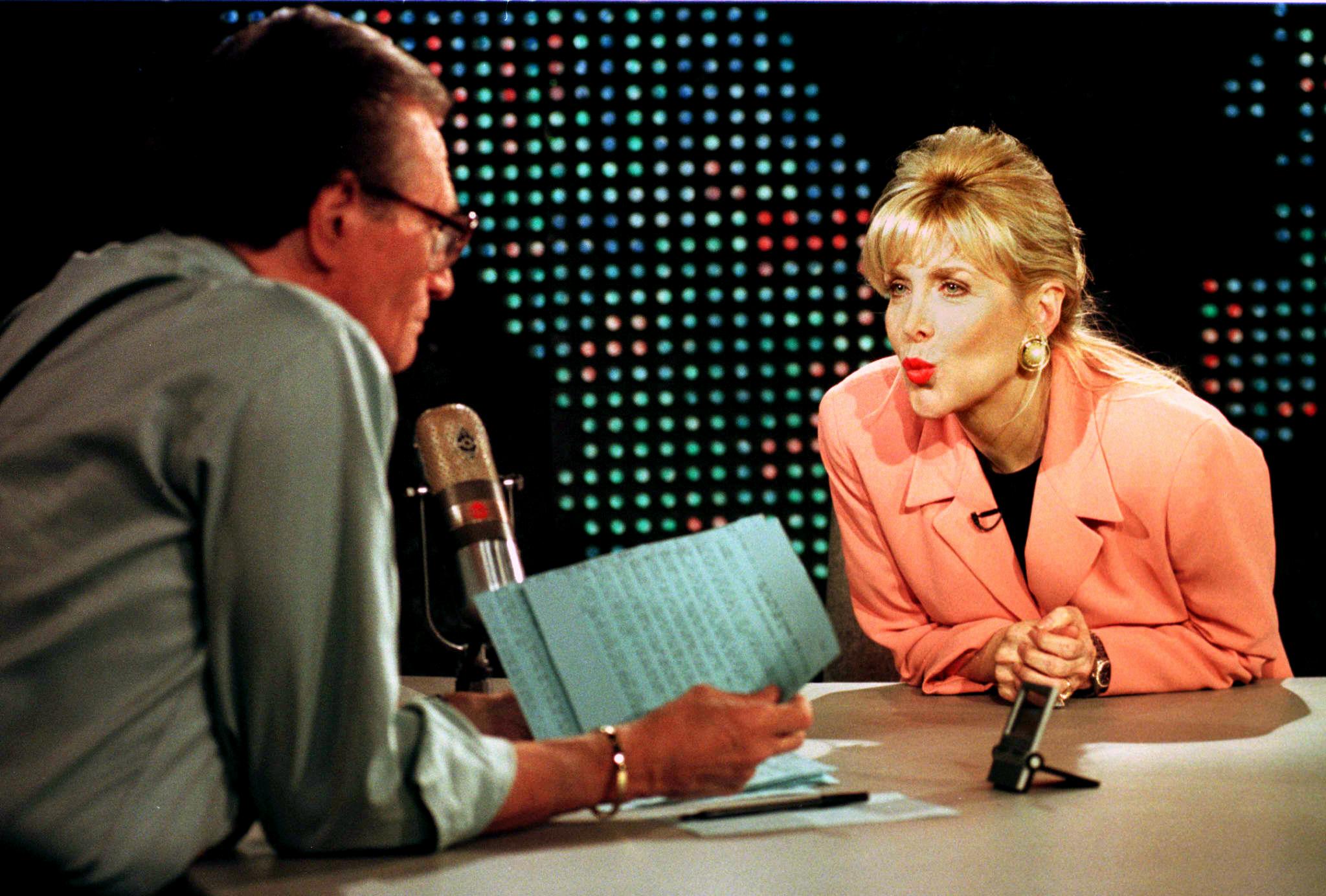Gennifer Flowers (R) blows a kiss to talk show host Larry King (L) during her live interview on CNN's Larry King Live show in Hollywood, CA.  According to reports leaked to the press, US President Bill Clinton admitted during a deposition in the Paula Jones investigation to having an affair with Flowers while he was governor of Arkansas.   RENE MACURA/AFP--Getty Images) (RENE MACURA&mdash;AFP/Getty Images)