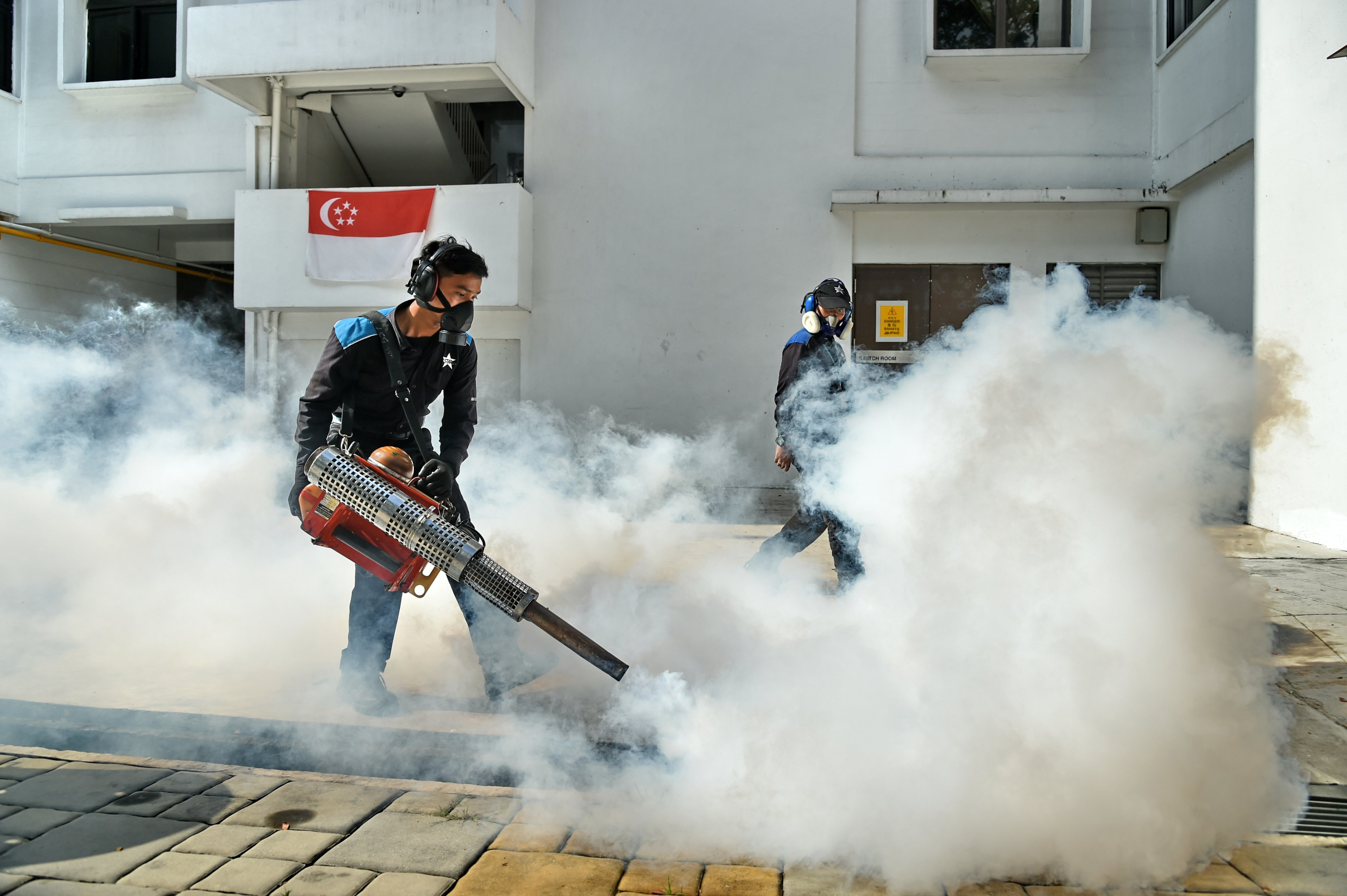 Pest control staff fumigate the drainage at the Macpherson neighbourhood housing estate in Singapore on August 31, 2016. (ROSLAN RAHMAN—;AFP/Getty Images)
