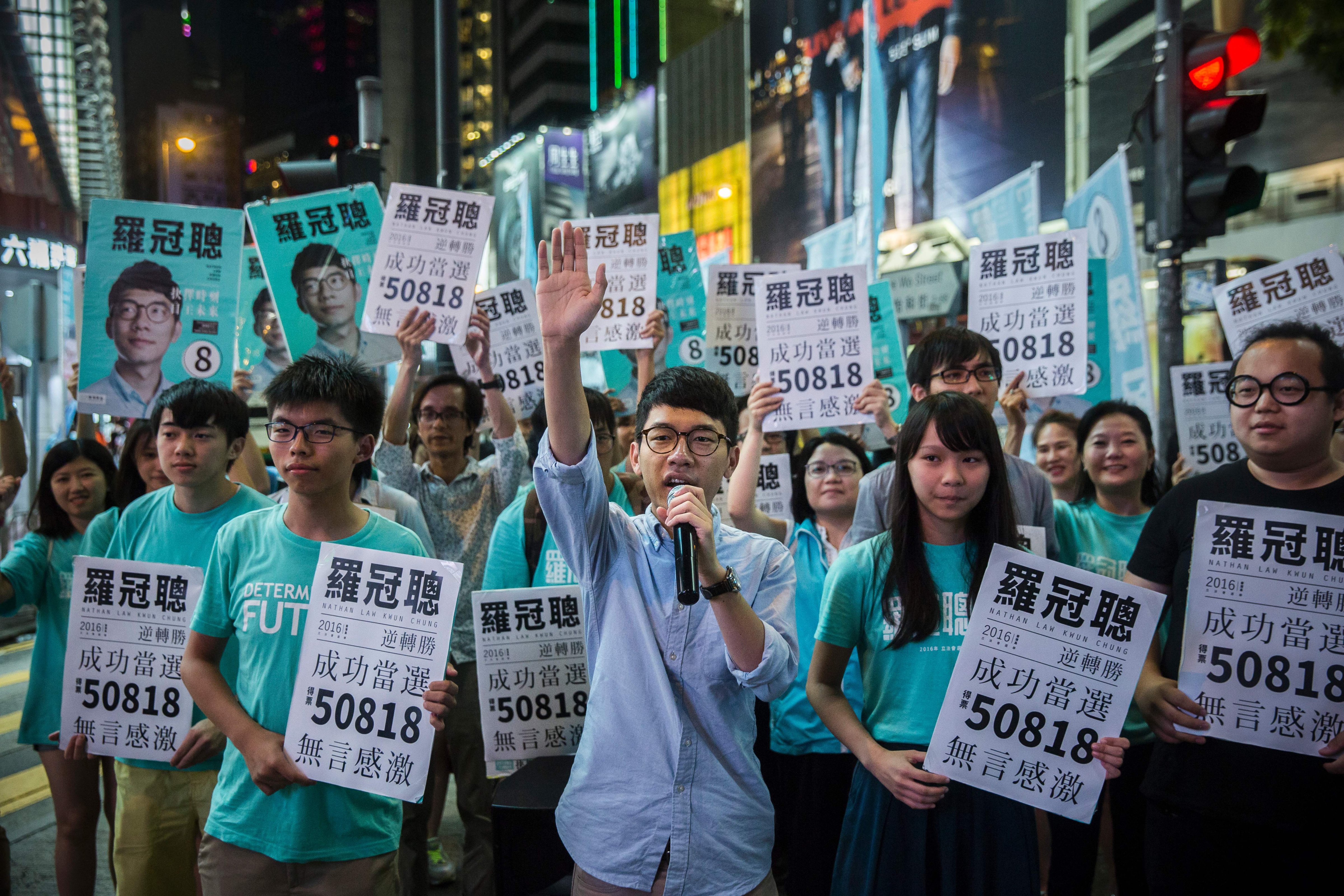 Nathan Law, center, speaks at a rally with Joshua Wong, center left, and other supporters in Causeway Bay, Hong Kong, following Law's win in the Legislative Council election on Sept. 5, 2016. A new generation of young Hong Kong politicians advocating a break from Beijing looked set to become lawmakers for the first time on Sept. 5 in the biggest poll since mass pro-democracy rallies in 2014 (Isaac Lawrence—AFP/Getty Images)