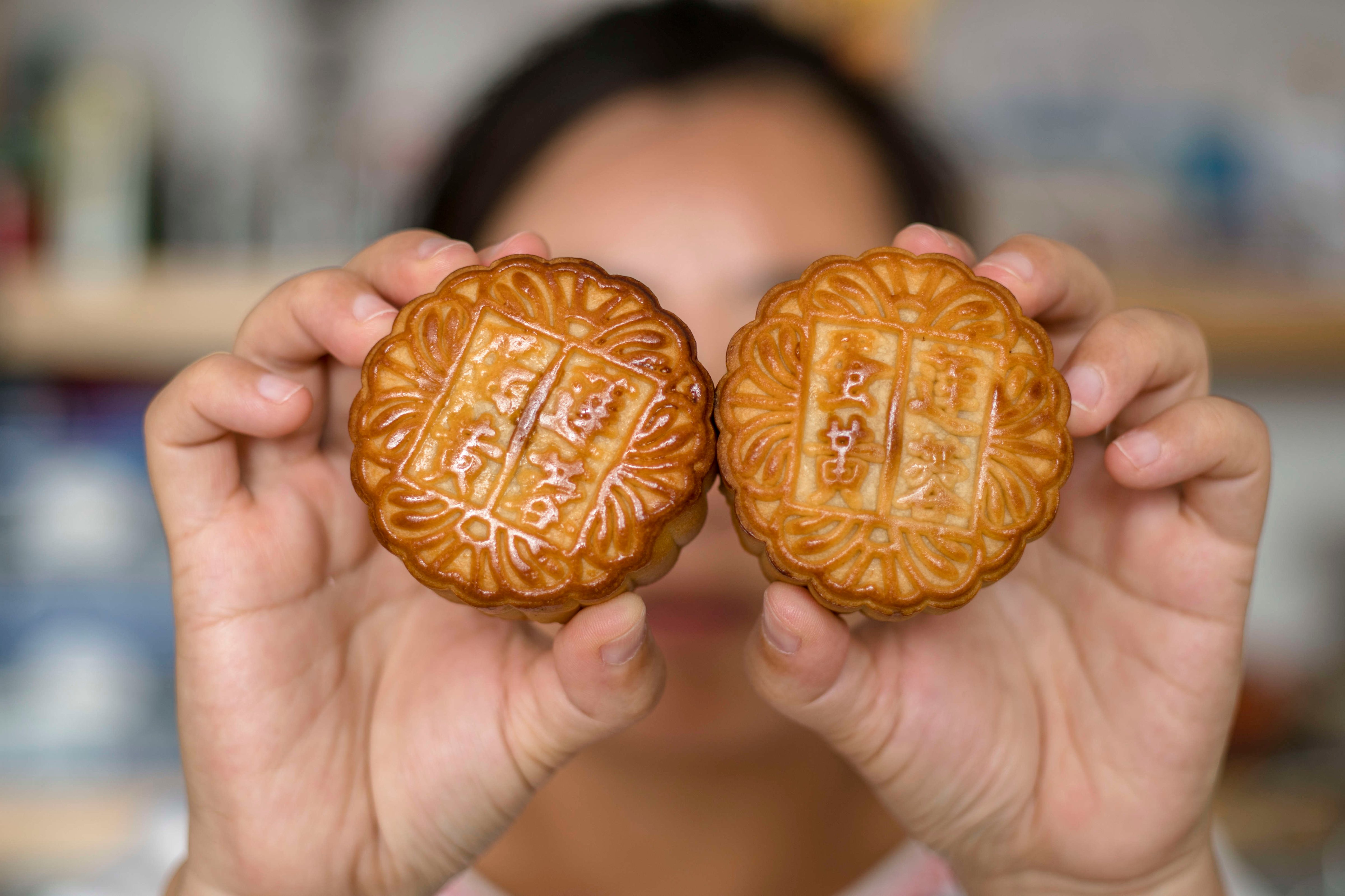 A woman in Beijing is holding moon cakes in her hands on Sept. 10, 2016 (Zhang Peng—LightRocket/Getty Images)