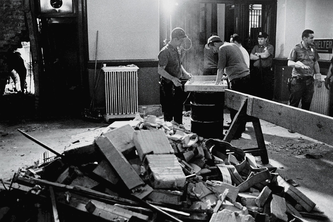 Construction workers and policemen stand around a pile of rubble in the police headquarters building after a bombing by the Weathermen Underground Organization, an offshoot of the SDS, New York, June 9, 1970. (David Fenton—Getty Images)