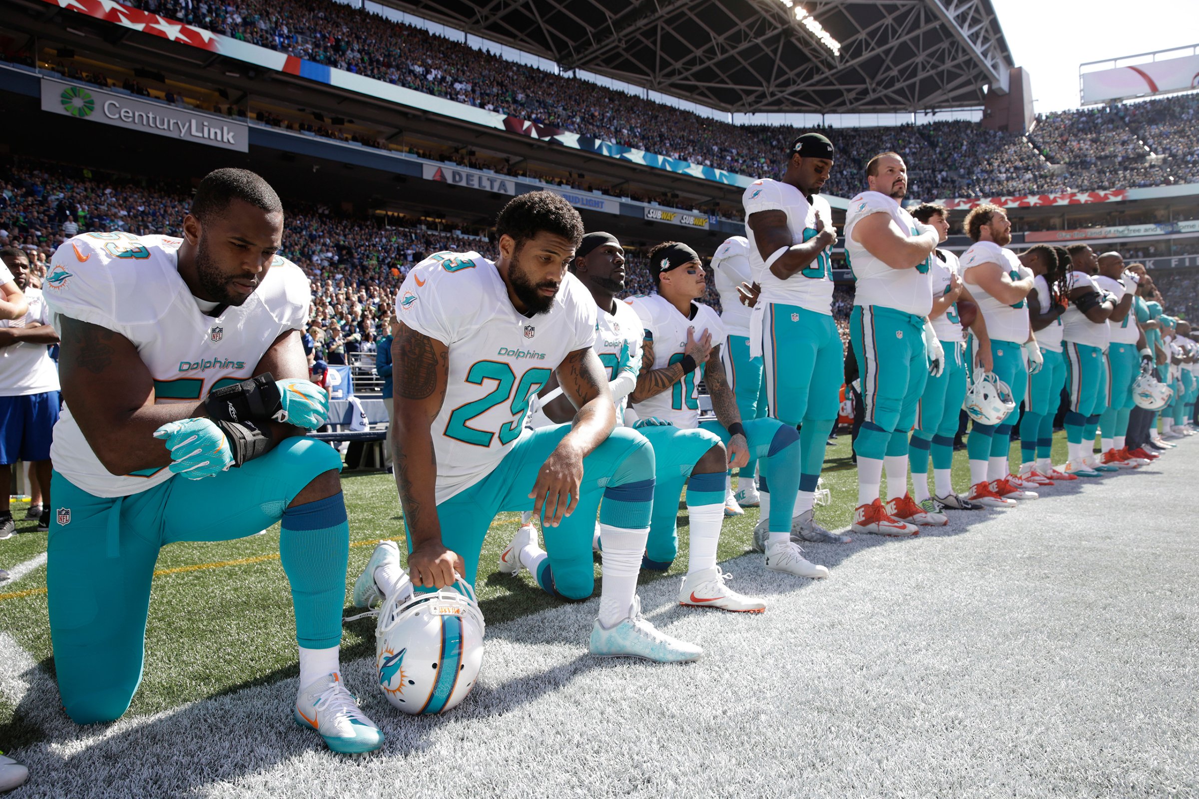 Jelani Jenkins, Arian Foster, Michael Thomas, and Kenny Stills of the Miami Dolphins kneel during the singing of the national anthem before a game against the Seattle Seahawks in Seattle on Sept. 11, 2016.