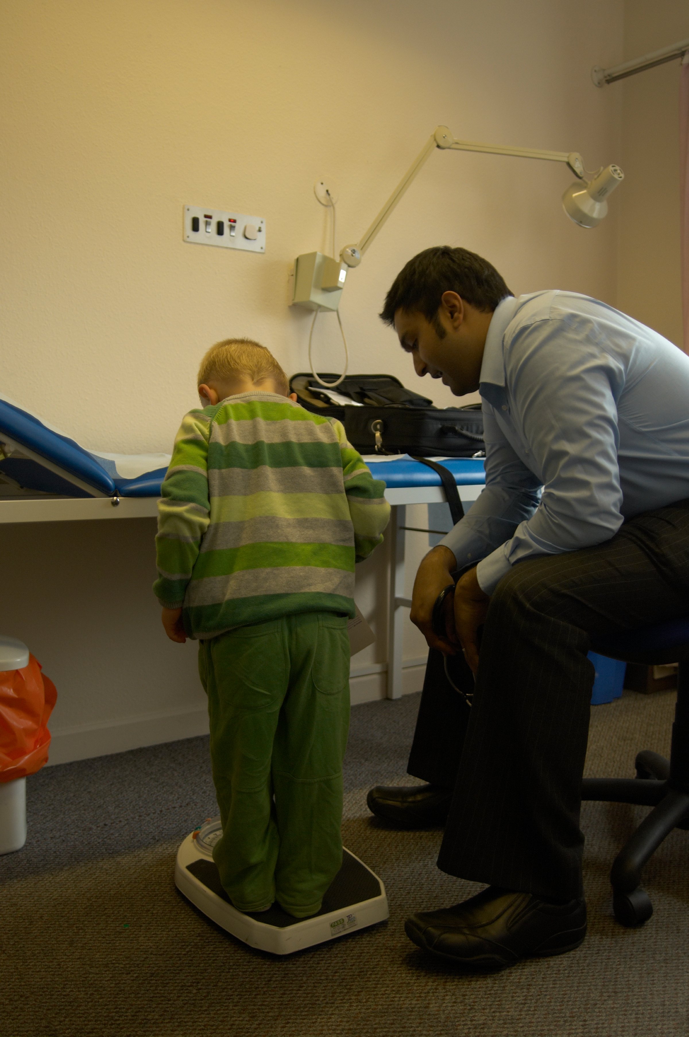 Doctor with child (2-4 years old) on weighing scales