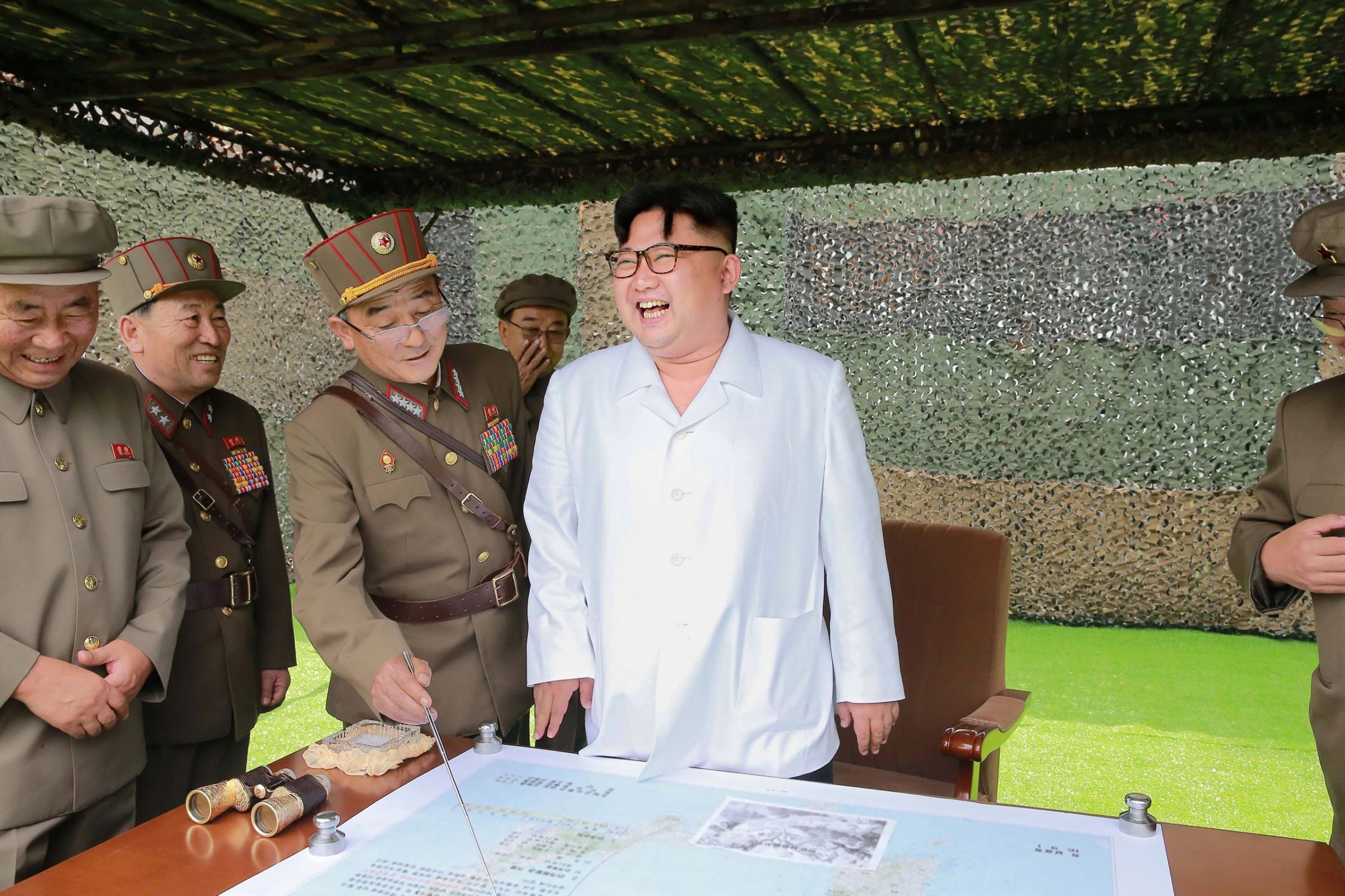North Korean leader Kim Jong Un confers with his generals during a demonstration of ballistic missiles