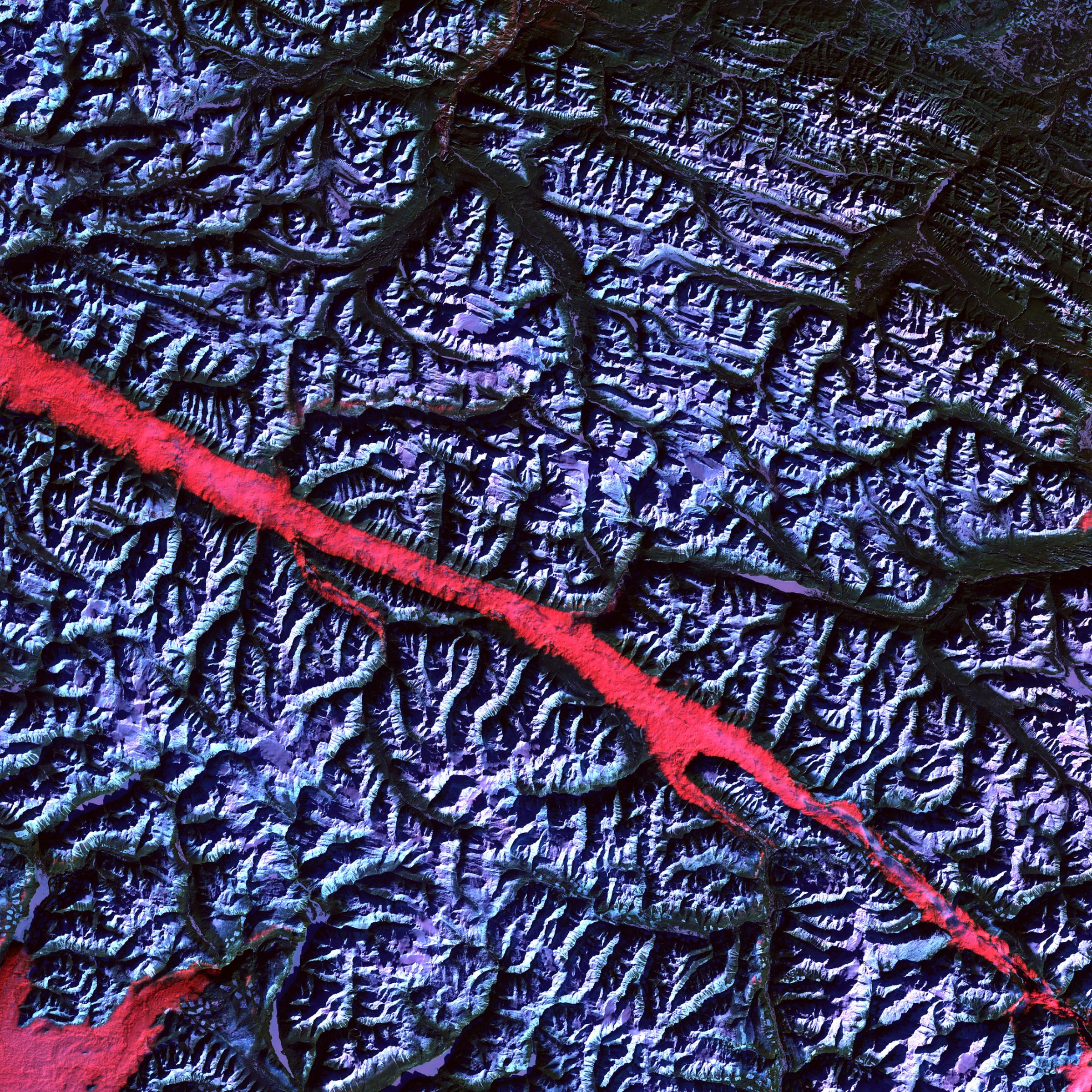 Rocky Mountain Trench, CanadaThe high reflectance of clouds compared to the surrounding land, coupled with the low sun elevation when this image was acquired, causes low clouds to appear red as they fill a portion of the trench. Feb. 2004.