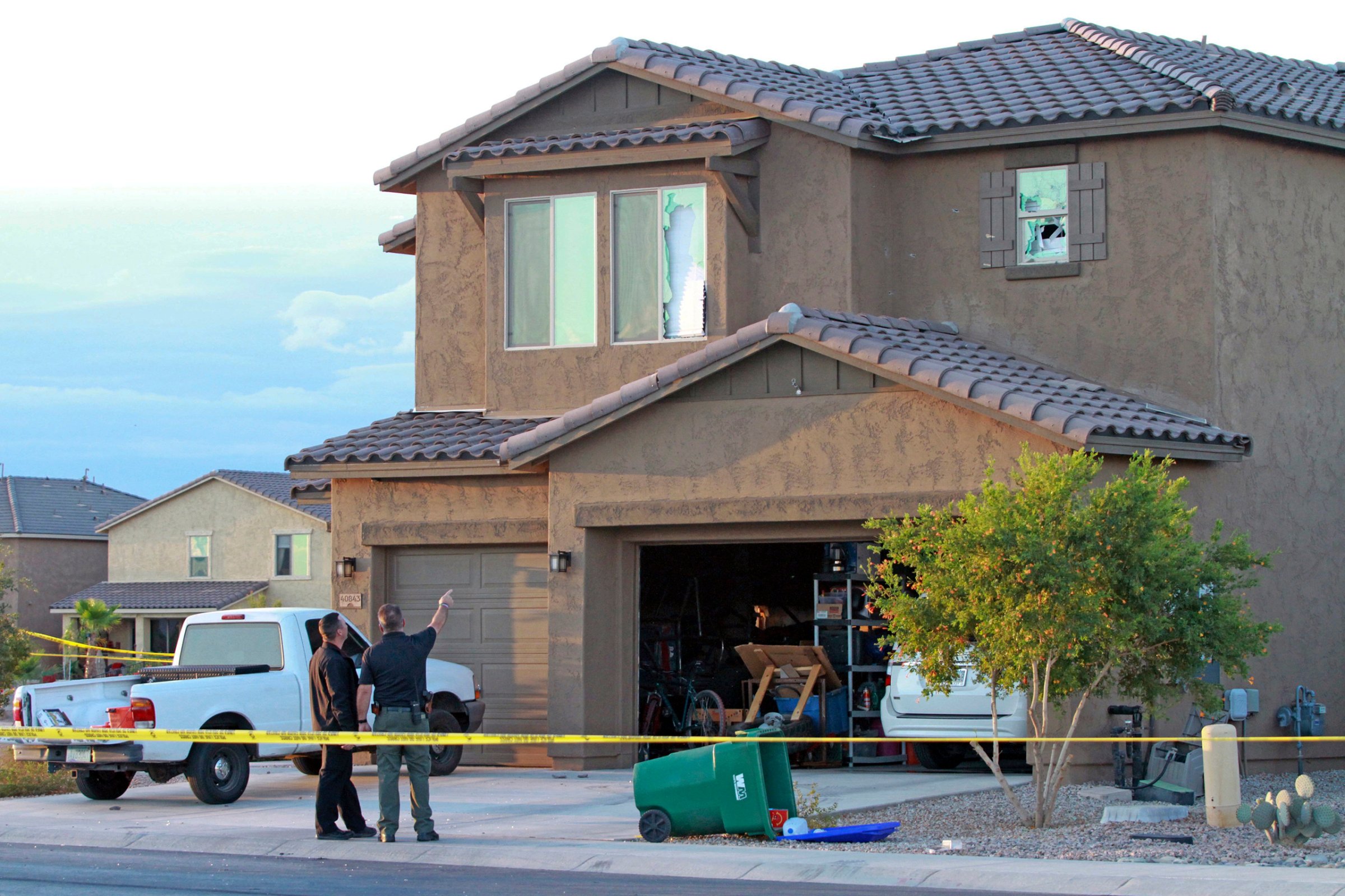 Police point to the window of a Maricopa home where a Border Patrol agent was found dead inside after exchanging gunfire with officers responding to a domestic violence call, Sept. 27, 2016.