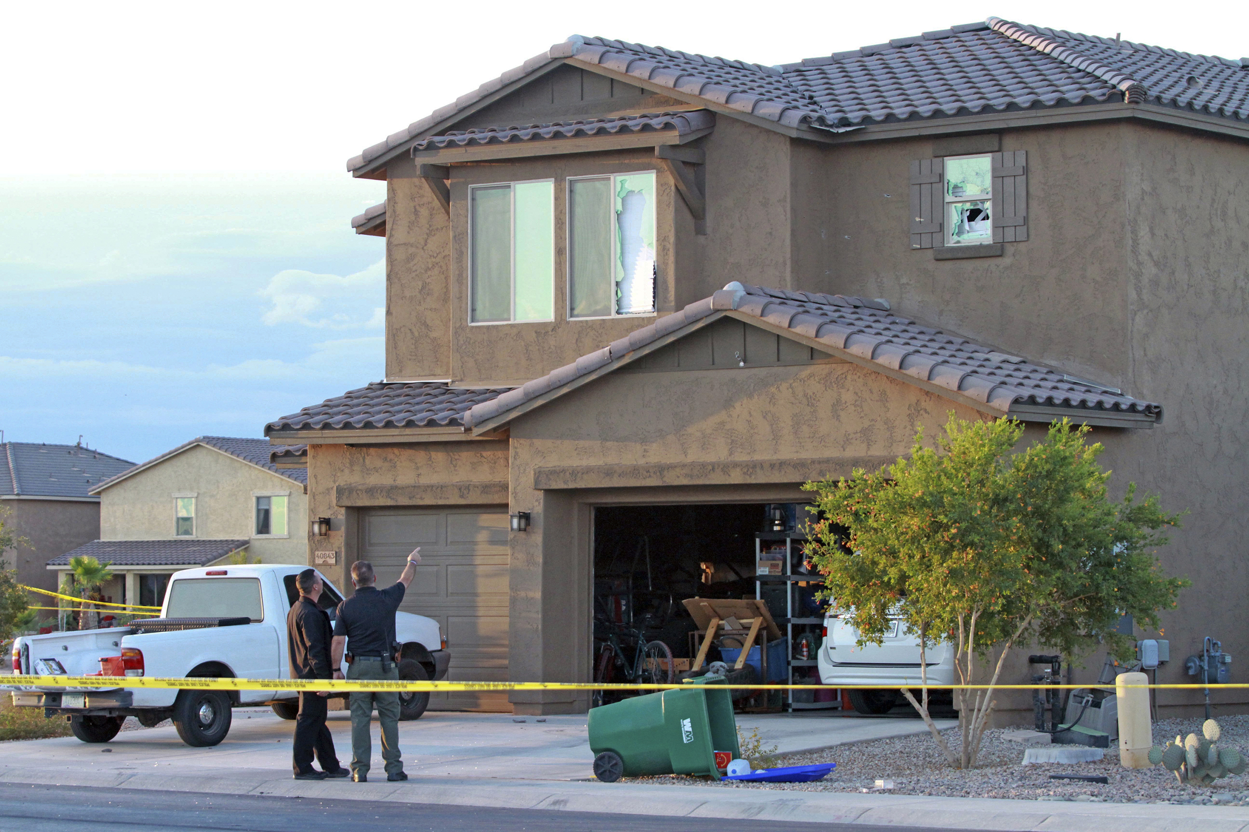 Police point to the window of a Maricopa home where a Border Patrol agent was found dead inside after exchanging gunfire with officers responding to a domestic violence call, Sept. 27, 2016. (Howard Waggner—Maricopa Monitor/AP)