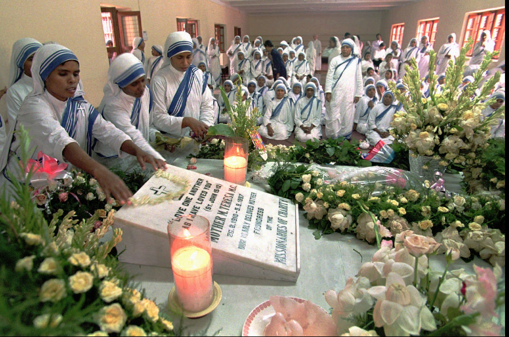 Sisters of the Missionaries of Charity decorate the tomb of Mother Teresa, who was buried after a state funeral, at Mother House in Calcutta, India, on Sept. 14, 1997.