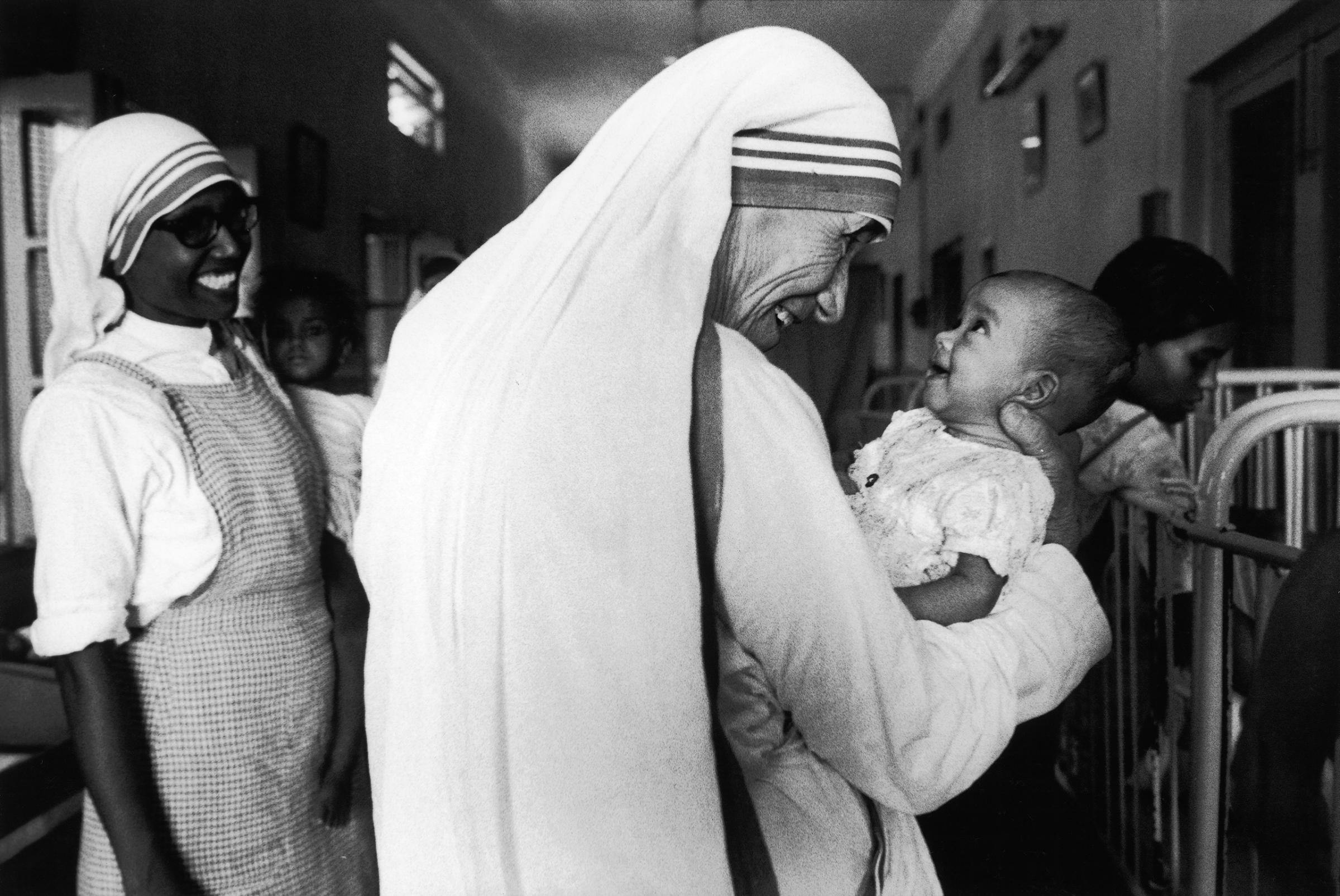 Mother Teresa smiles with an infant in Calcutta, India, in 1981.