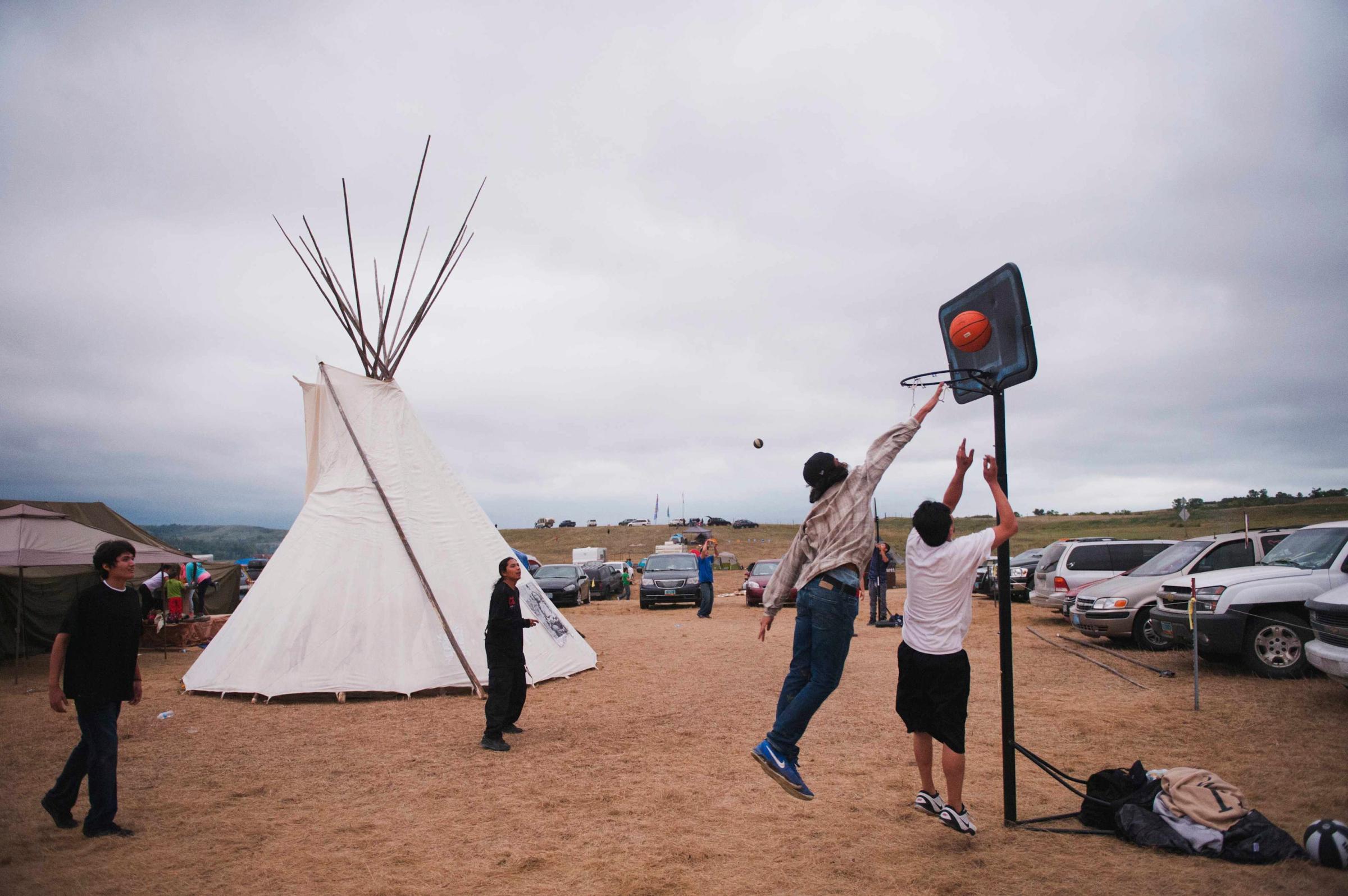 Native American protesters play basketball in an encampment that has grown on the banks of the Cannon Ball River in Cannon Ball, North Dakota, on Sept. 5, 2016.