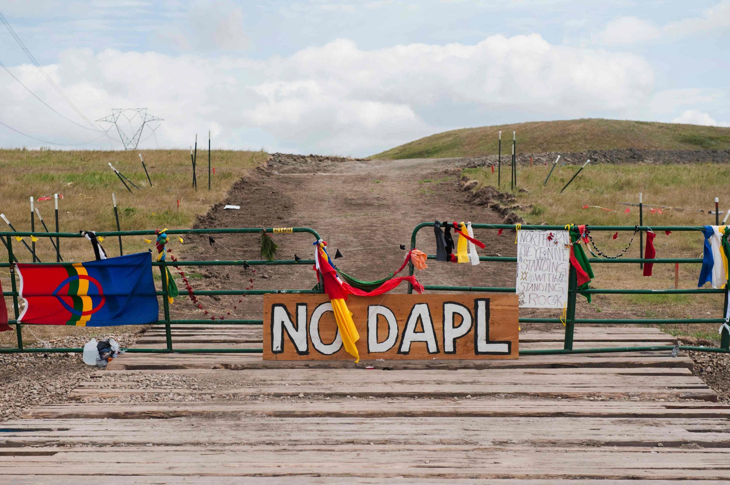 Signs left by protesters demonstrating against the Energy Transfer Partners Dakota Access oil pipeline sit at the gate of a construction access road in Cannon Ball, North Dakota on Sept. 6, 2016.