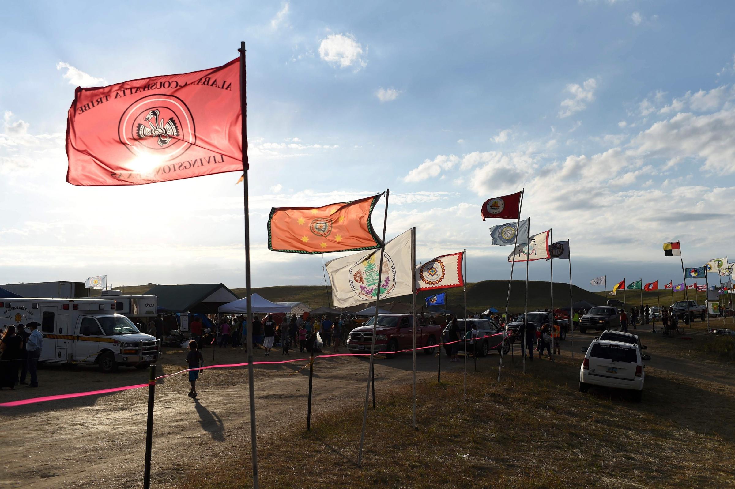 Flags of Native American tribes from across the US and Canada line the entrance to a protest encampment near Cannon Ball, North Dakota on Sept. 3, 2016.