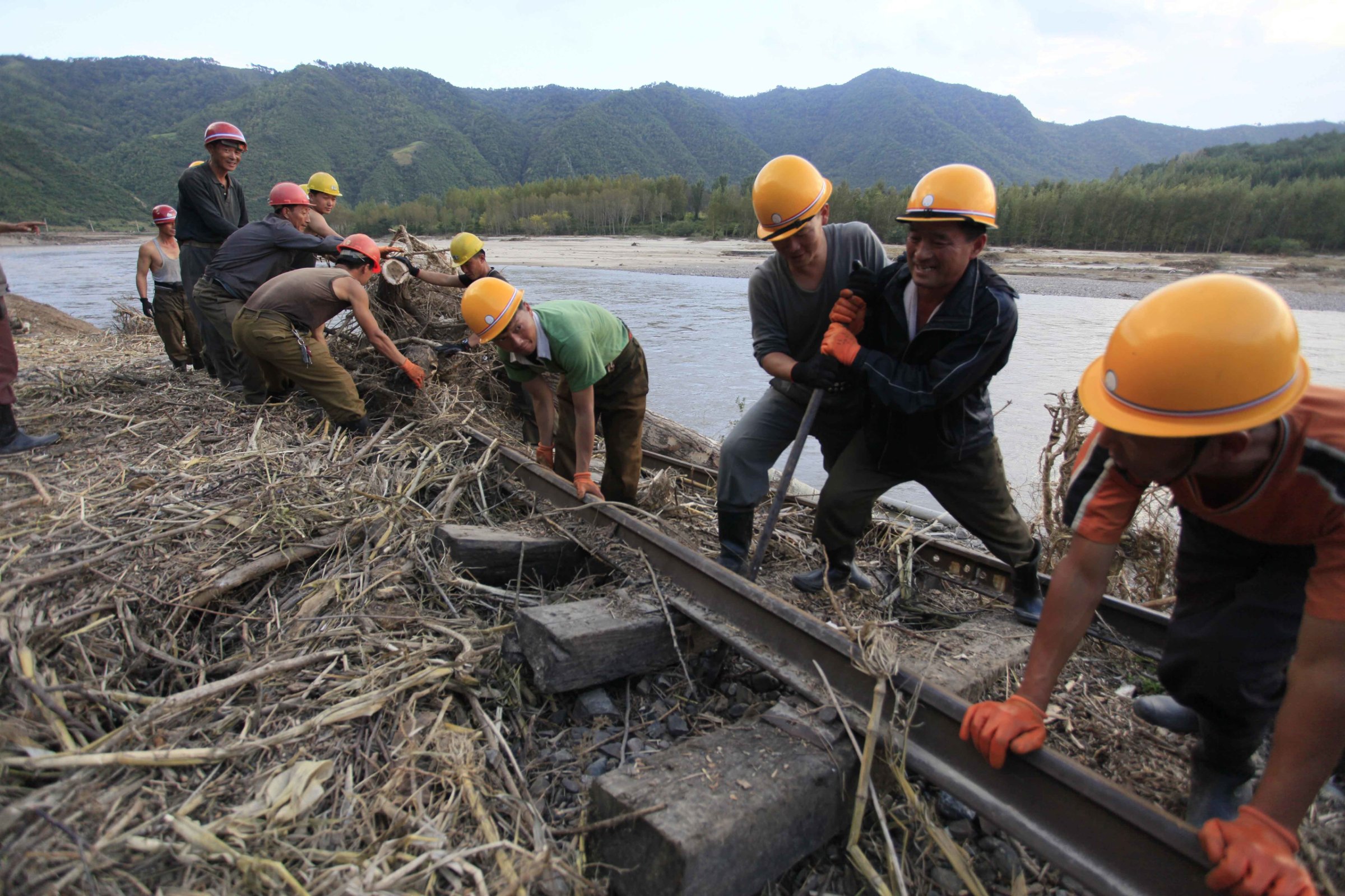 Workers repair the flood-damaged train track between Sinjon and Kanphyong train stations in North Hamgyong Province, North Korea, Friday, Sept. 16, 2016. North Korean soldiers and relief teams rushed to clear roads and railway tracks, build shelters and provide food and sanitation Friday to tens of thousands of residents in a remote part of the country near the Chinese border that was devastated by heavy downpours and flash-floods when a typhoon pounded their villages last week. (AP Photo/Kim Kwang Hyon)
