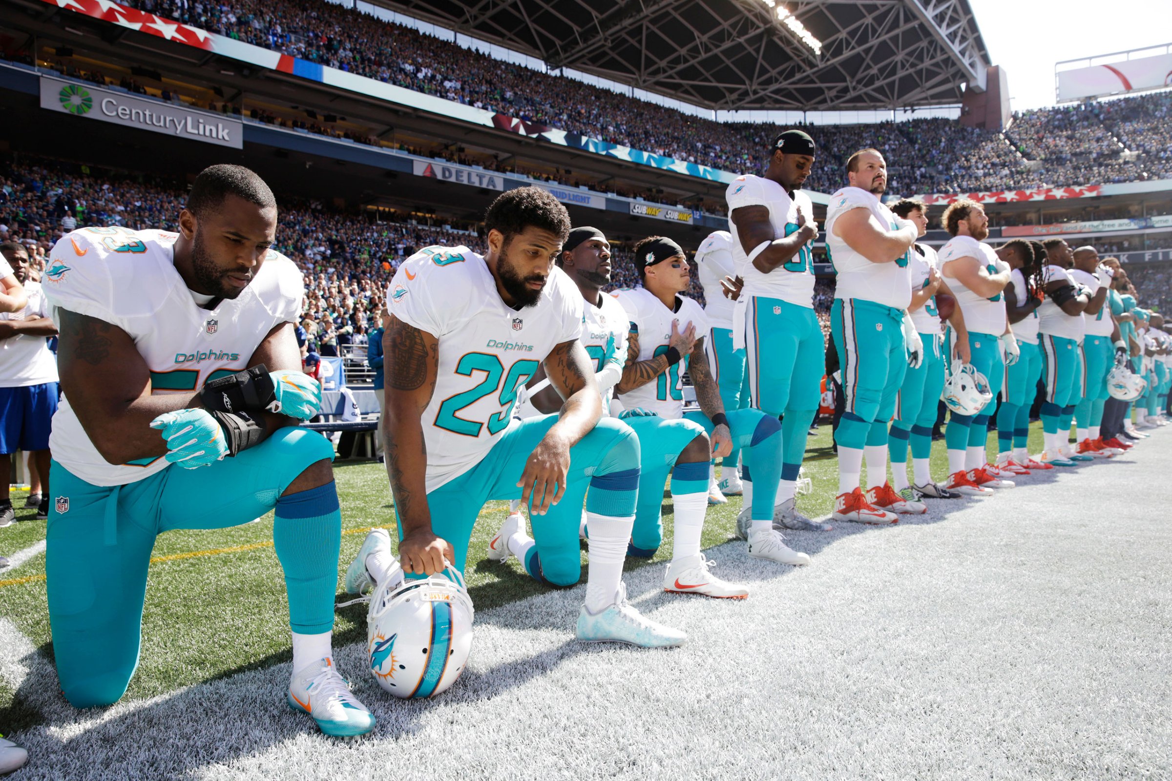 From left, Miami Dolphins Jelani Jenkins, Arian Foster, Michael Thomas and Kenny Stills kneel during the national anthem on Sept. 11
