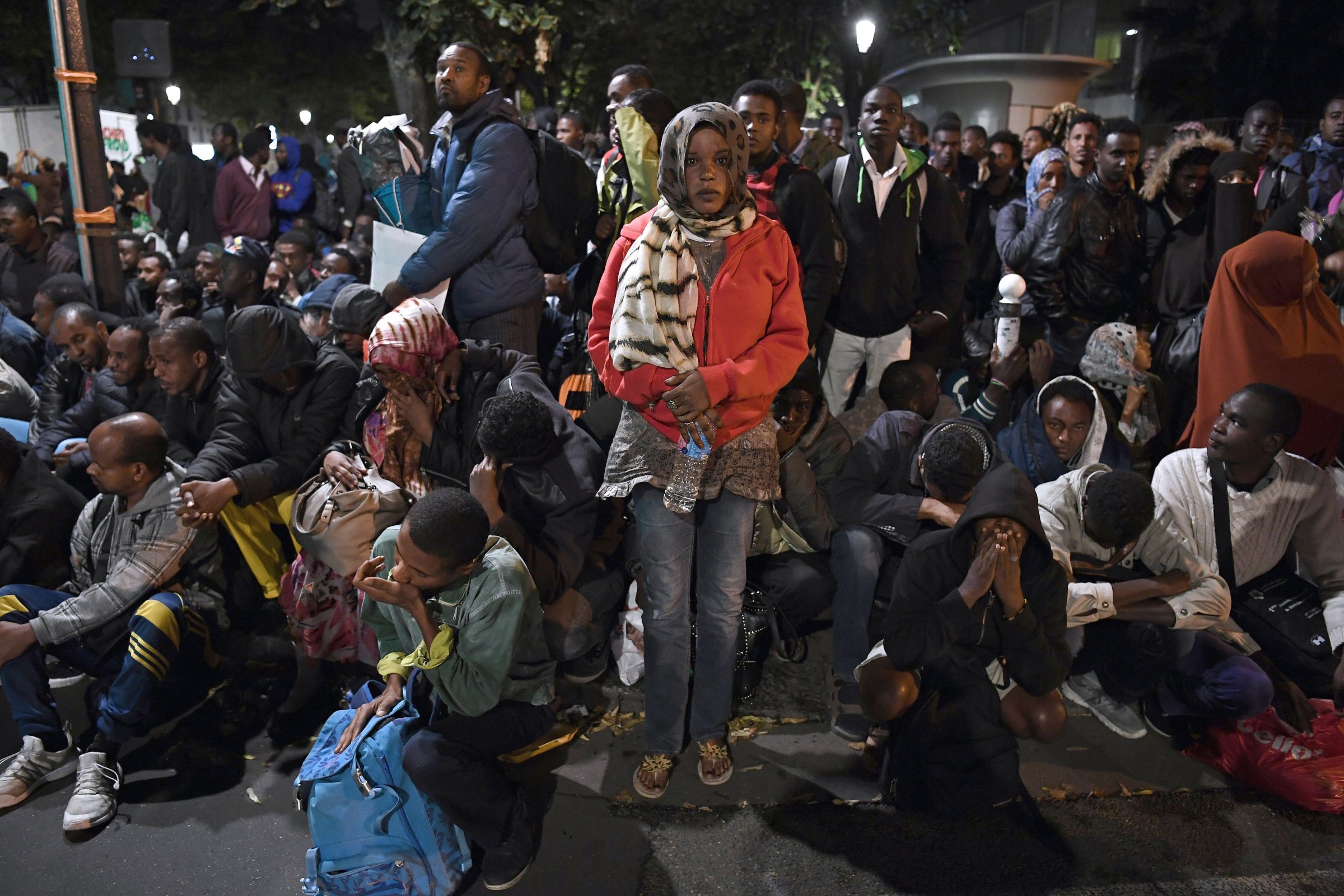 Migrants gather and wait before being evacuated from a makeshift migrant camp set up between the metro stations of Jaures and Stalingrad, in Paris on Sept. 16, 2016.