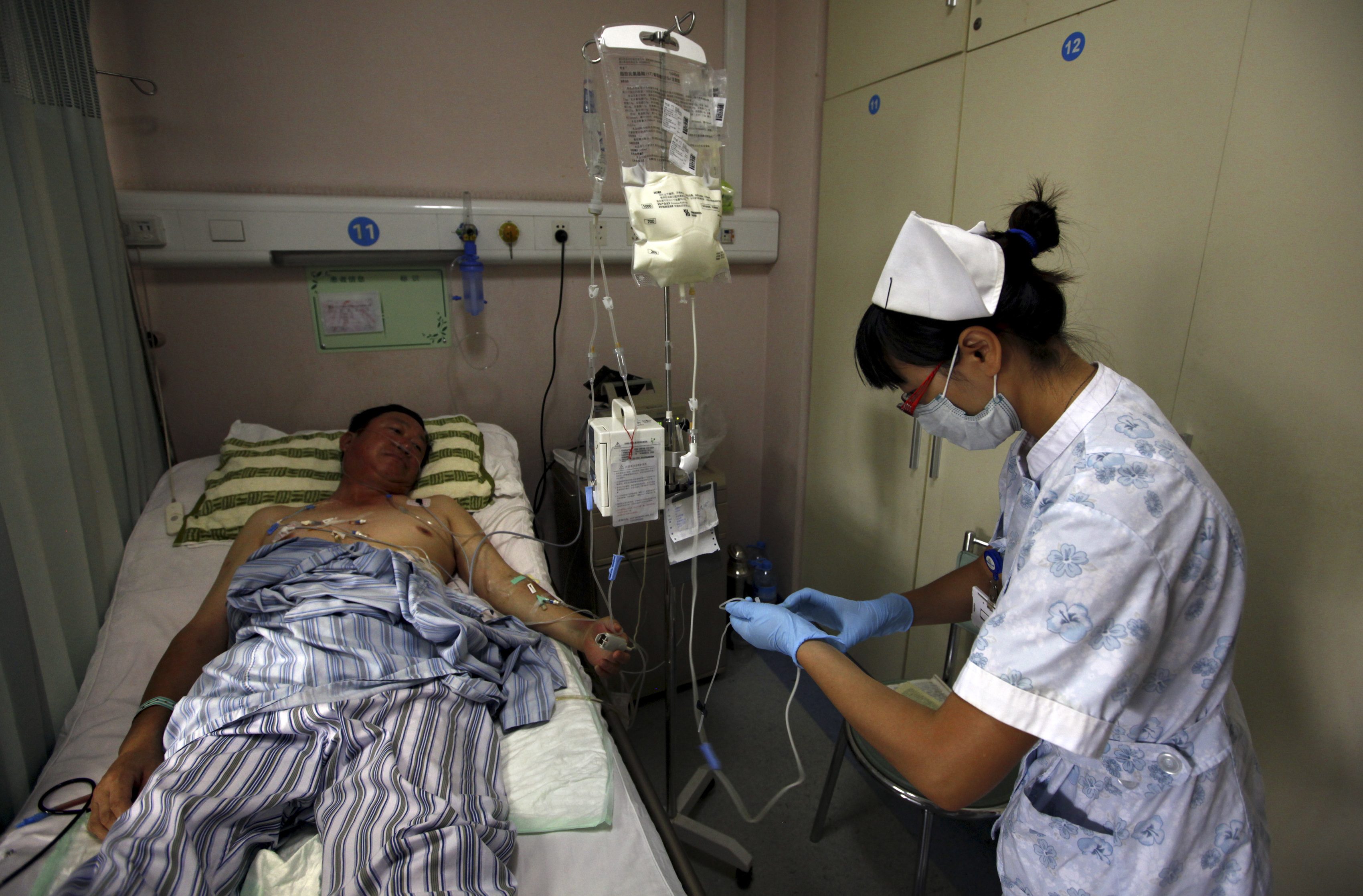 A nurse prepares to inject a cancer patient with medicine as she performs her daily rounds at the Beijing Cancer Hospital in this file photo from 2011. Cancer is spreading in China and kills millions annually (David Gray—Reuters)