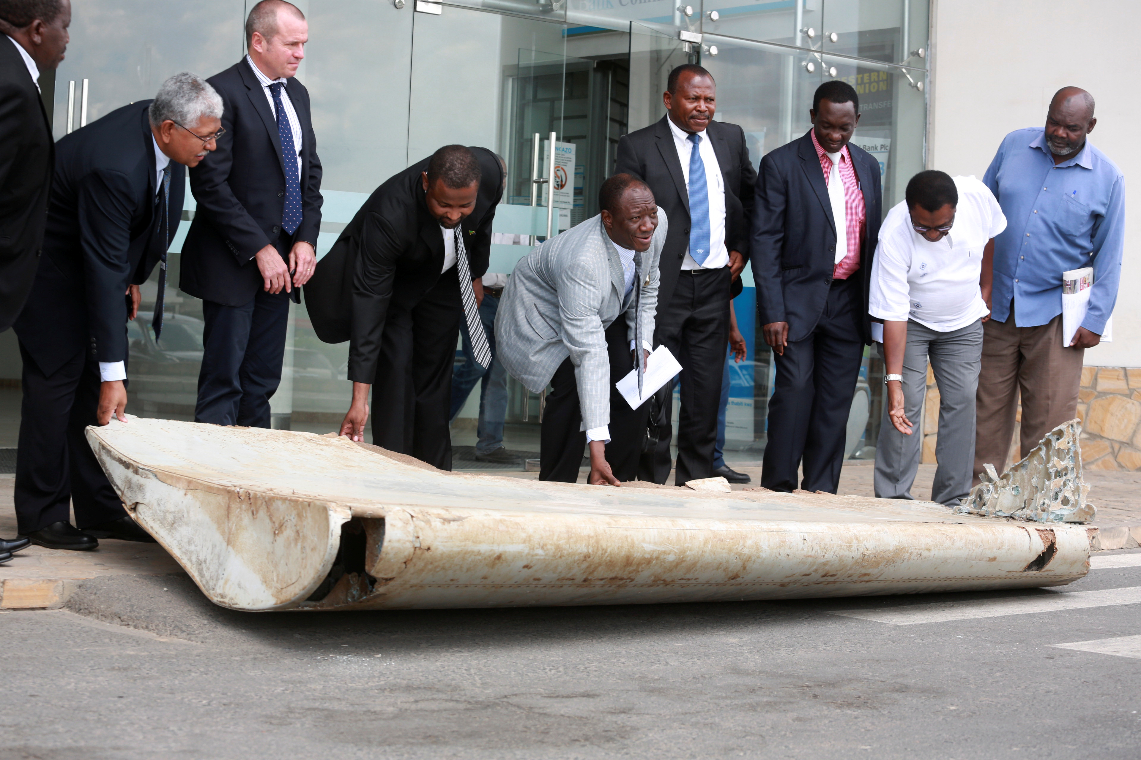 Tanzania Permanent Secretary to the Ministry of Works, Transport and Communication Leonard Chamuriho hands over a fragment suspected to be from the missing MH 370 in Dar es Salaam, Tanzania, on July 15, 2016 (Stringer/Reuters)