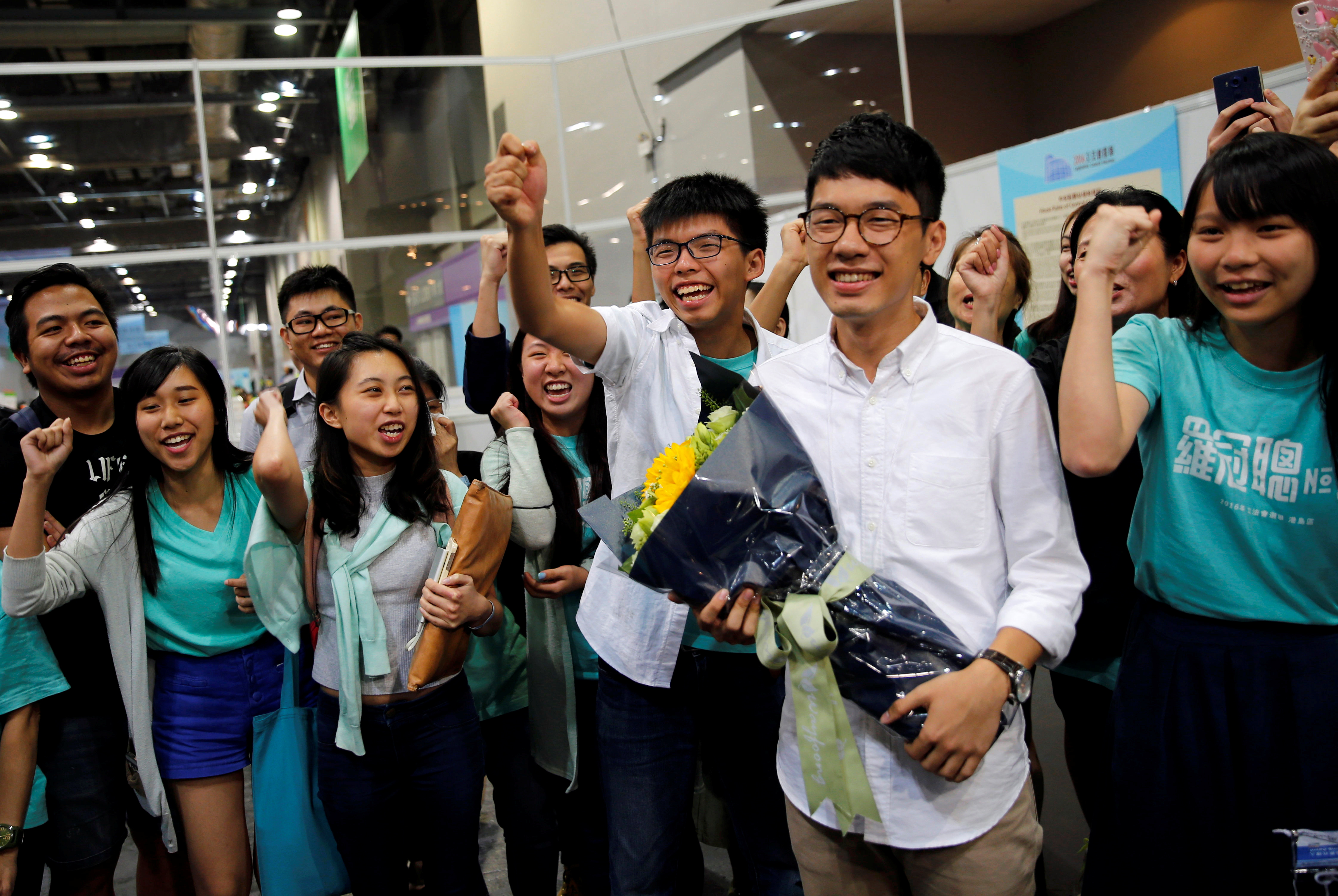 Student leader Joshua Wong greets candidate Nathan Law as supporters share their joy after Law won in the Legislative Council election in Hong Kong, China
