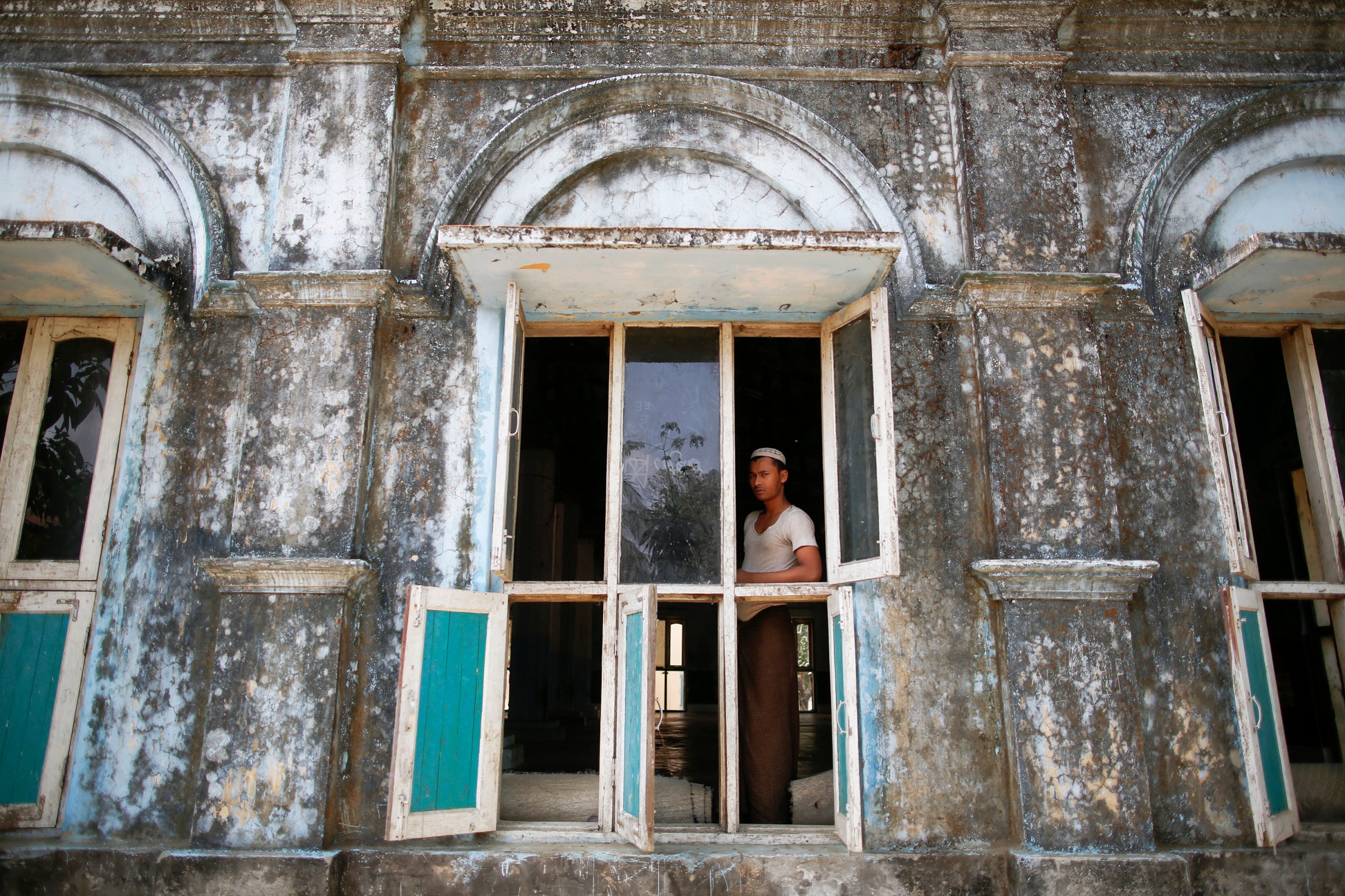A Rohingya Muslim student stands at a window of a local mosque near Sittwe