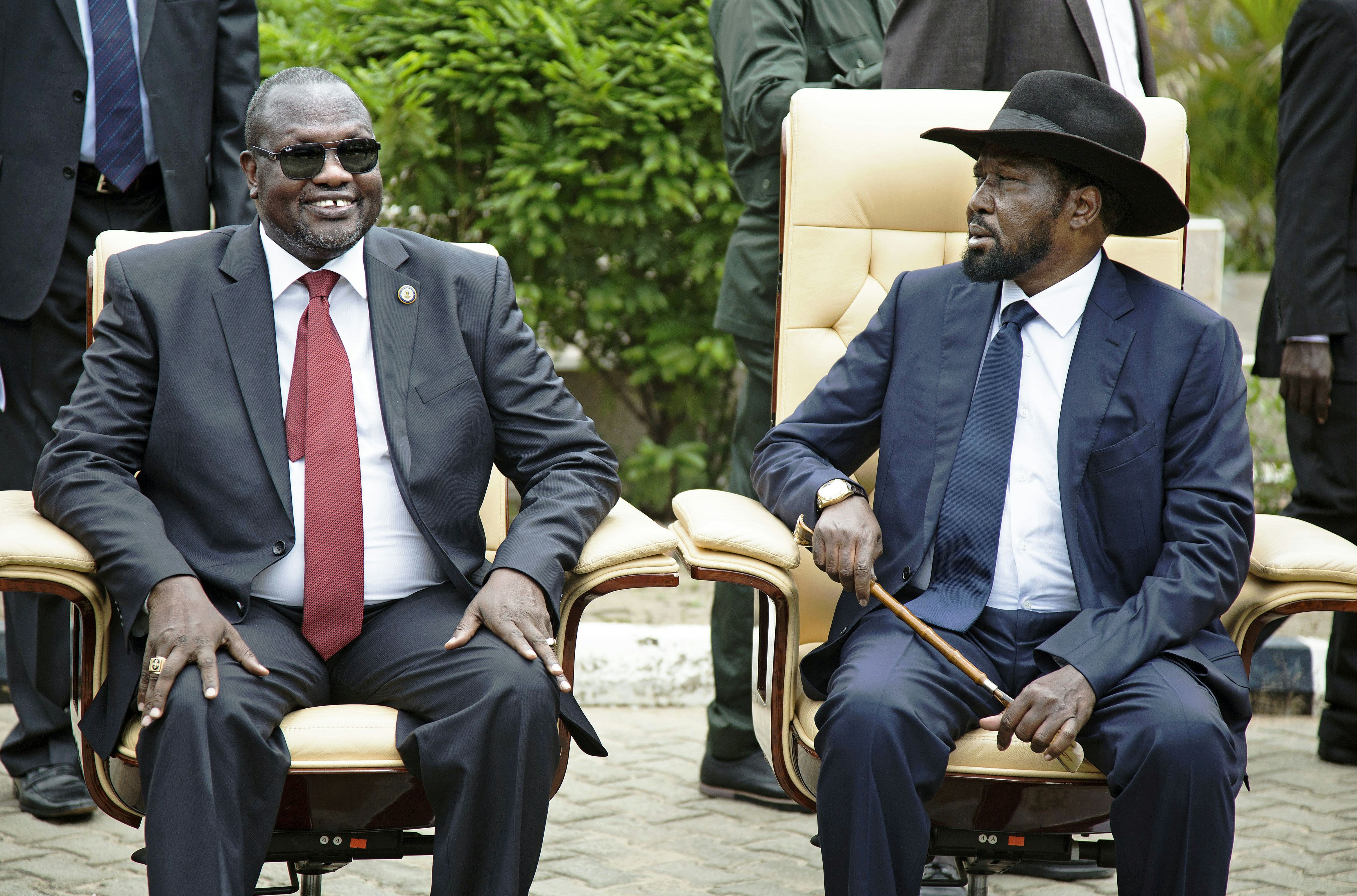 First Vice President of South Sudan and former rebel leader, Riek Machar (L), and President Salva Kiir (R), sit for an official photo with the 30 members of the new cabinet of the Transitional Government at the Cabinet Affairs Ministry, in Juba on April 29, 2016. (ALBERT GONZALEZ FARRAN—AFP/Getty Images)