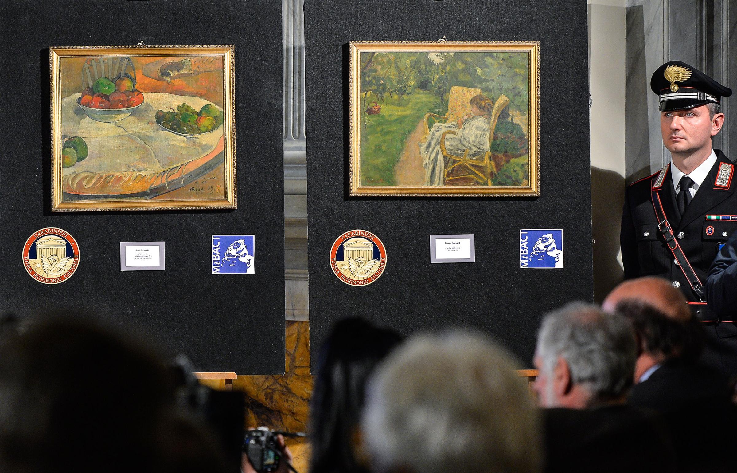 A Carabinieri stands next to the two paintings stolen in London in the 1970s, "Fruits sur une table ou nature morte au petit chien" by French artist Paul Gauguin and "La femme aux deux fauteuils" by Pierre Bonnard, on April 2, 2014.