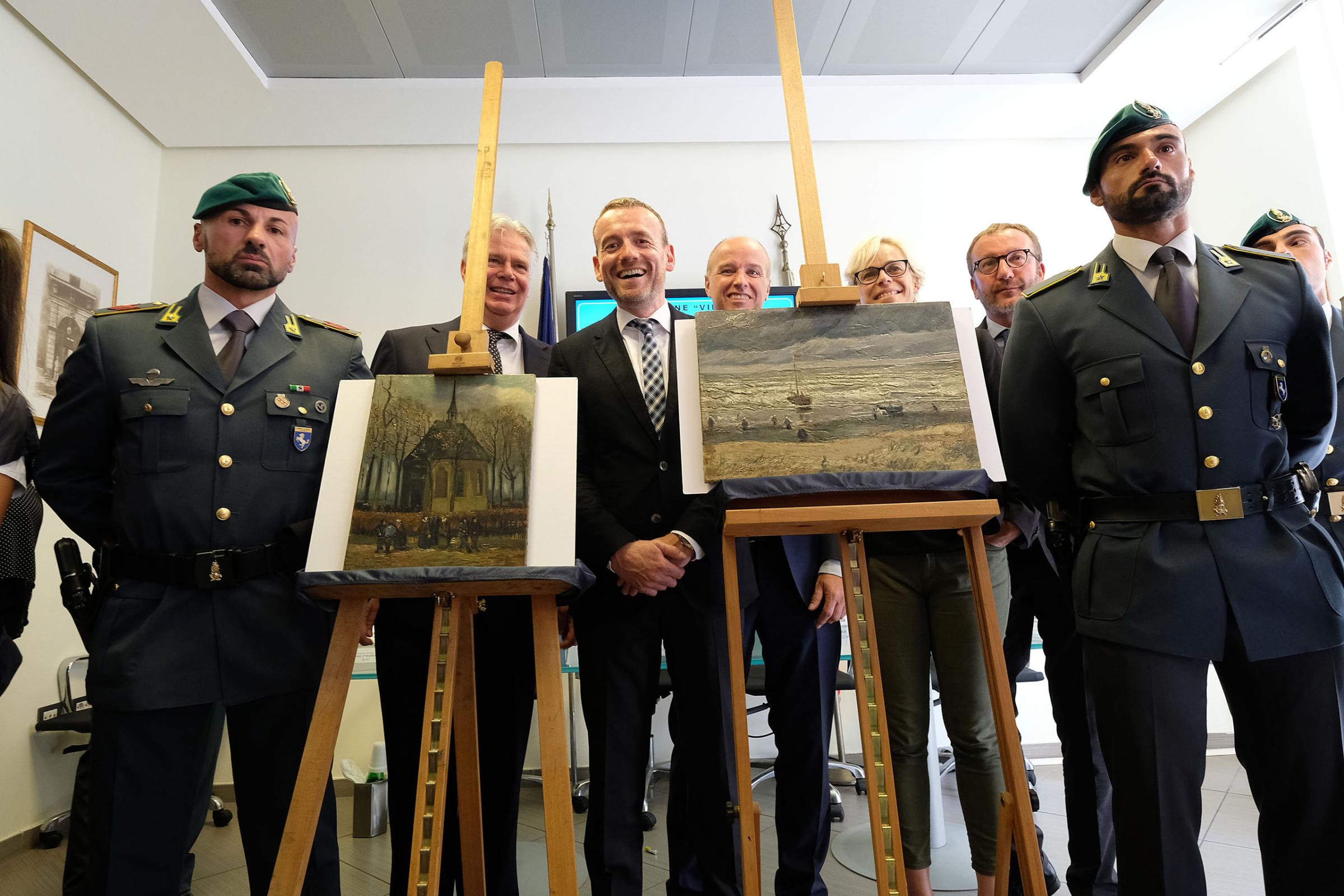 Axel Ruger, Director of the Van Gogh museum, poses next to "Congregation Leaving the Reformed Church in Nuenen" (L) and "The Beach At Scheveningen During A Storm" (R) by Vincent van Gogh. The two Van Gogh paintings were stolen in Amsterdam 14 years ago and recently recovered by organized crime investigators in Italy, on Sept. 30, 2016.