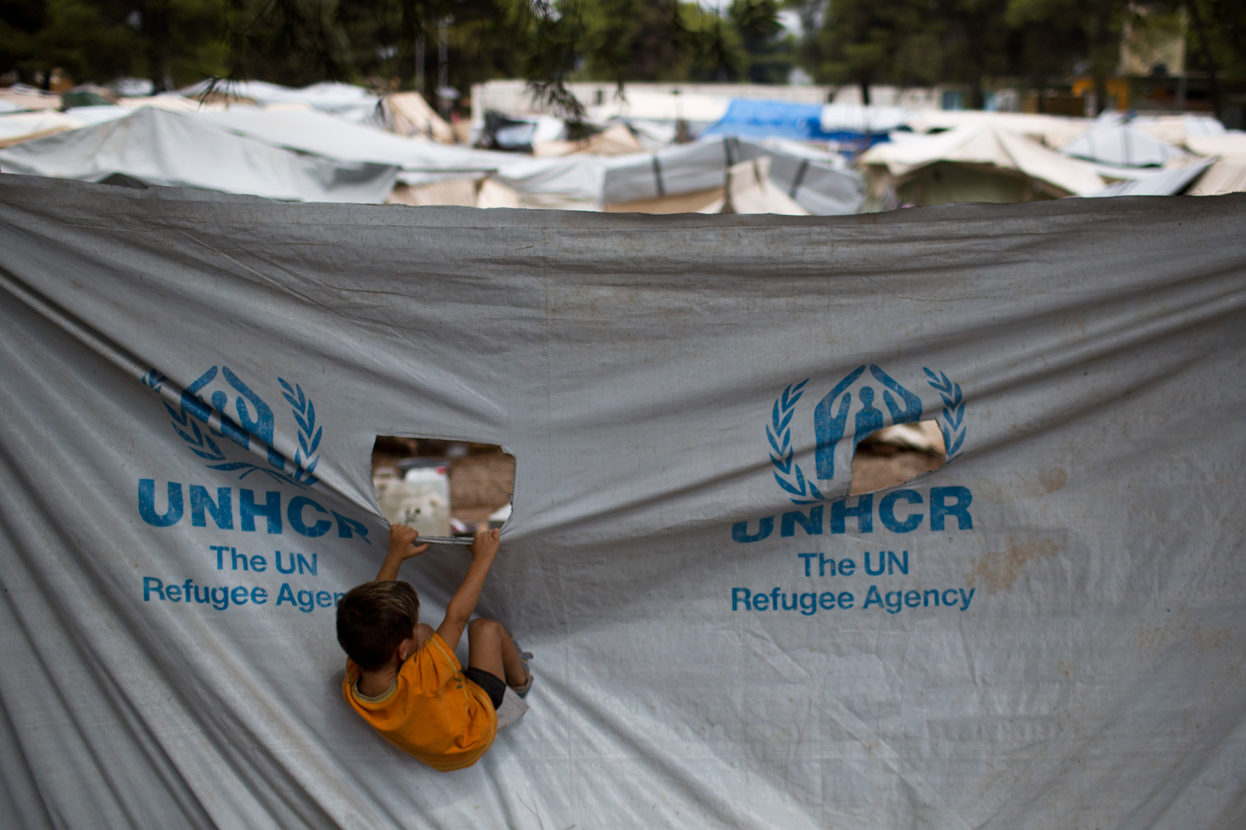 A child play in front of a UNHCR plastic sheet at Ritsona refugee camp, north of Athens, on Sept. 8, 2016. (Petros Giannakouris—AP)