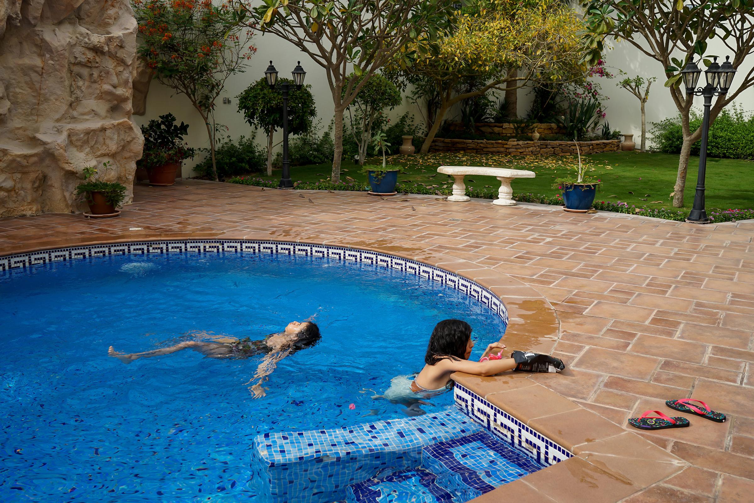 The photographer's daughters, Sura and Yara, swim in a pool at a friend's home in Dhahran, Saudi Arabia, April 2016. "They lay there, free, and careless," Alsultan says. "There's no public pools for women, neither is there any beach spaces for women only. Only privately owned or very expensive clubs that is not available to Saudis."
