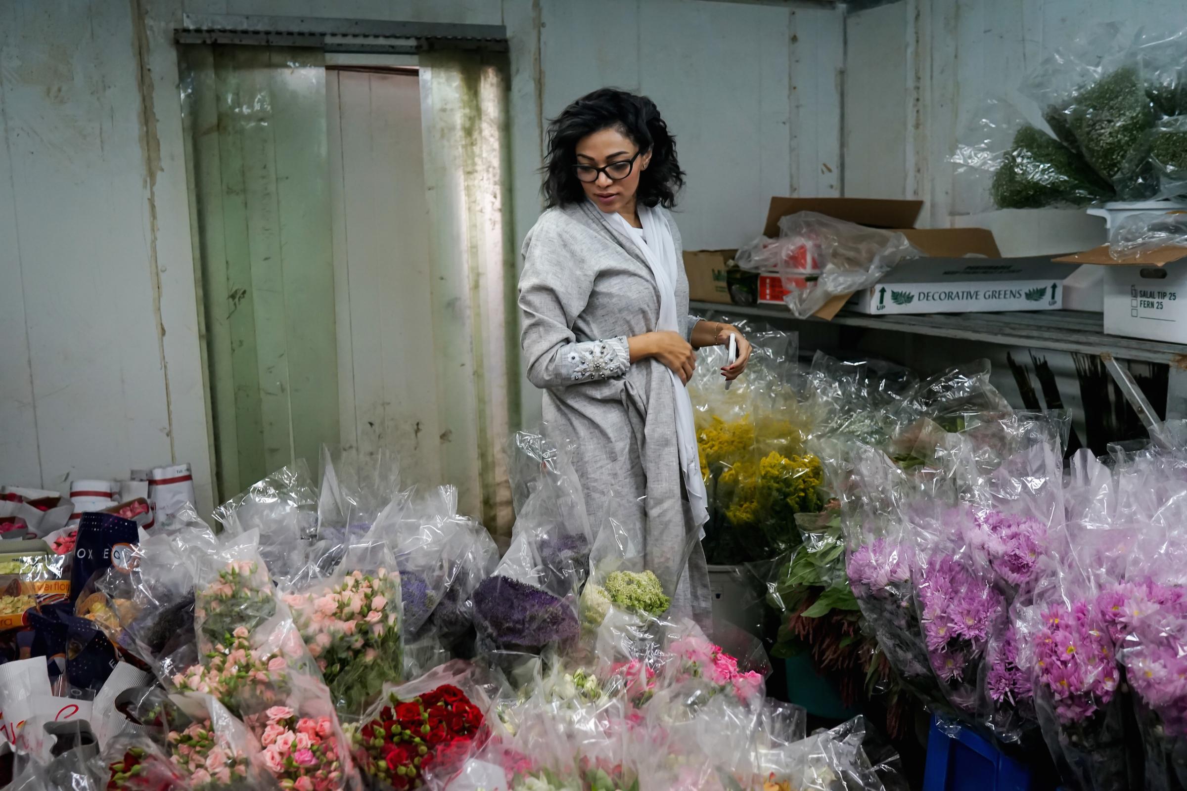 Ghadeer, a well-known wedding planner in Saudi Arabia, chooses flowers for an upcoming event at a florist in Jeddah, May 2016. A friend of the photographer, she says she has never been married or in love.