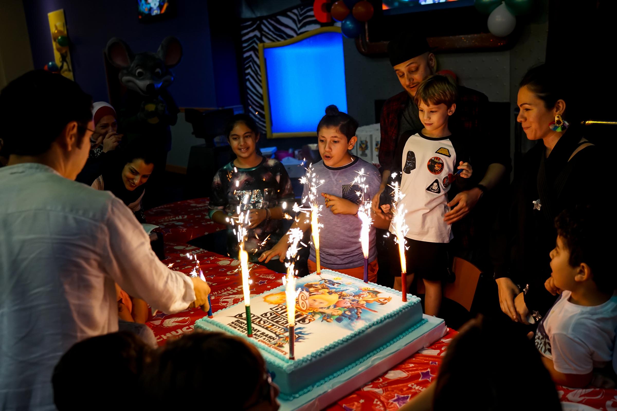 Nasiba, along with family and friends and the boy's father, her ex-husband, celebrate his 5th birthday at a Chuck E. Cheese's in Jeddah, May 2016.